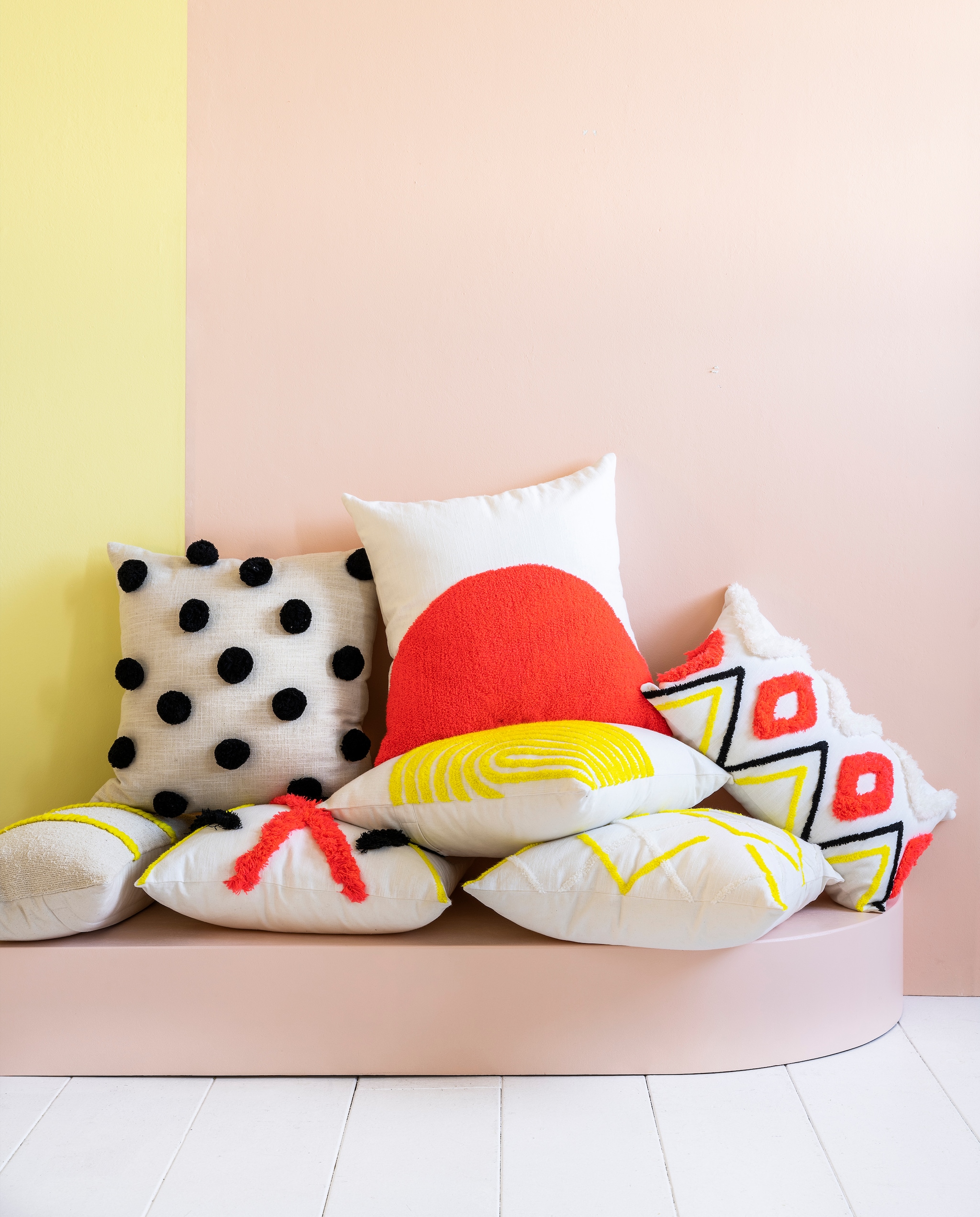 Neon Collectie 03-2023. Katoenen kussen met pompoms, 45x45 cm € 39,95, katoenen kussen met oranje halve maan, 45x45 cm € 44,95, katoenen kussens met oranje-geel-zwarte print, 50x30 cm € 34,95 en 45x45cm € 49,95, katoenen kussens met gele lijnen, 50x30cm € 39,95 en 45x45 cm € 44,95, katoenen kussen met gele hoekversiering, 45x45 cm € 44,95. vtwonen 03-2023 | productie &amp; styling Tanja Saarberg | fotografie Stan Koolen | assistentie Suzanne Fennema, Isa Hoevens