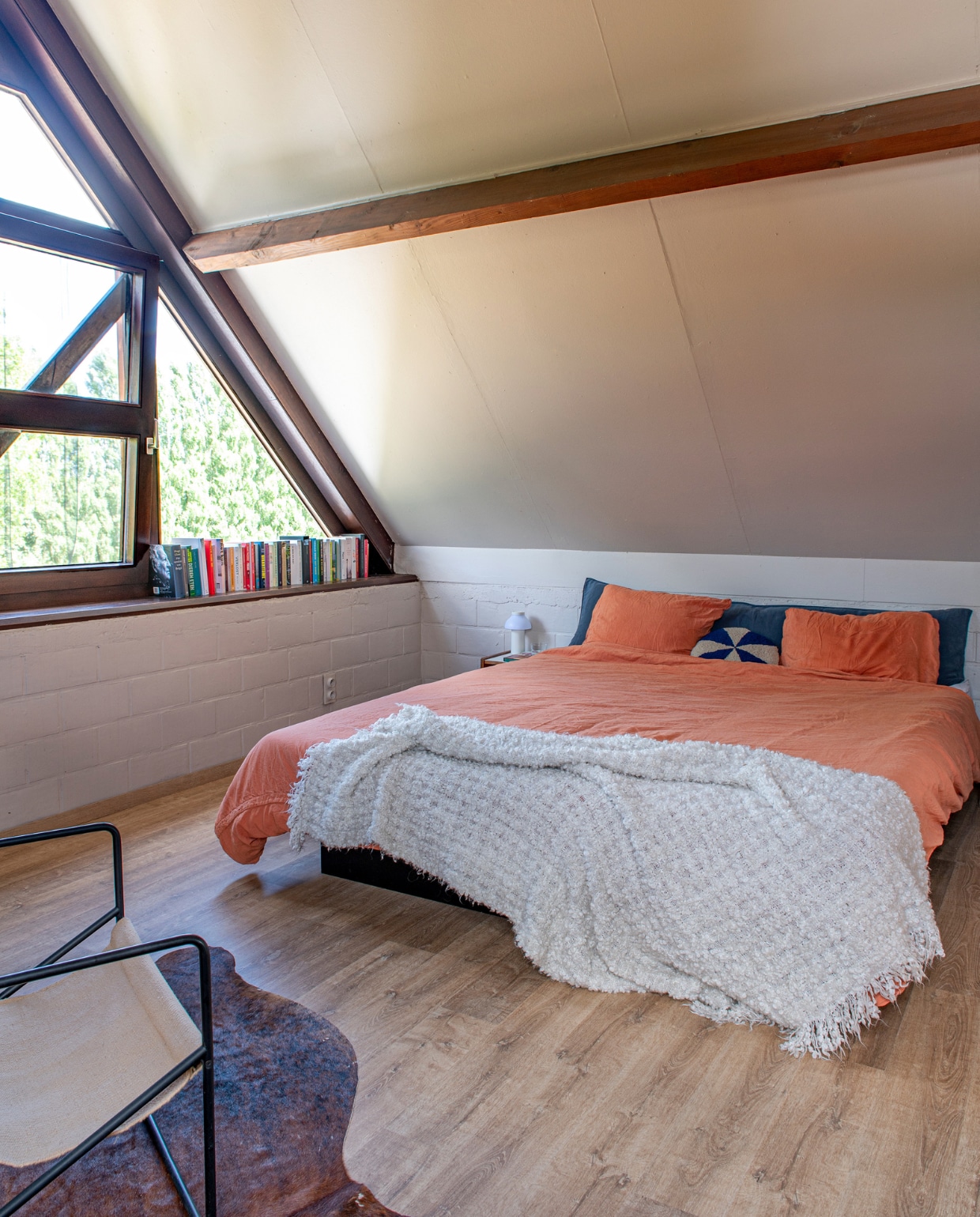 Vloer Van der Perre. Kleur op de muur door vorige bewoners. Stoel Ferm Living. Vloerkleed dierenvel onbekend. Beddengoed Suite 702. Sprei Ikea. Kussentje Ferm Living. Nachtlamp Hay. vtwonen 03-2023 | productie De Binnenkijkers | styling Jeske Weel | fotografie Caroline Coehorst