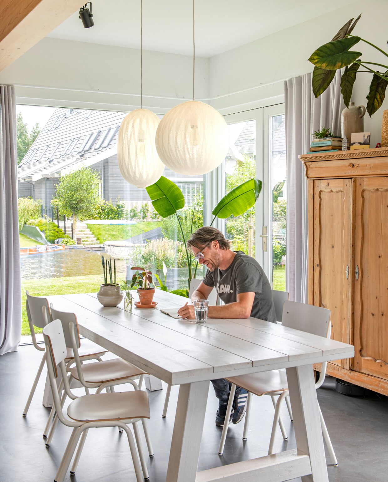 Eettafel Voordeeltafels, stoelen Zuiver, lampen Bel+Bo, gordijnen Veneta, kast en kruik uit ouderlijk huis, plantenpot op tafel Intratuin. vtwonen 03-2023 | productie De Binnenkijkers | styling Jeske Weel | fotografie Caroline Coehorst