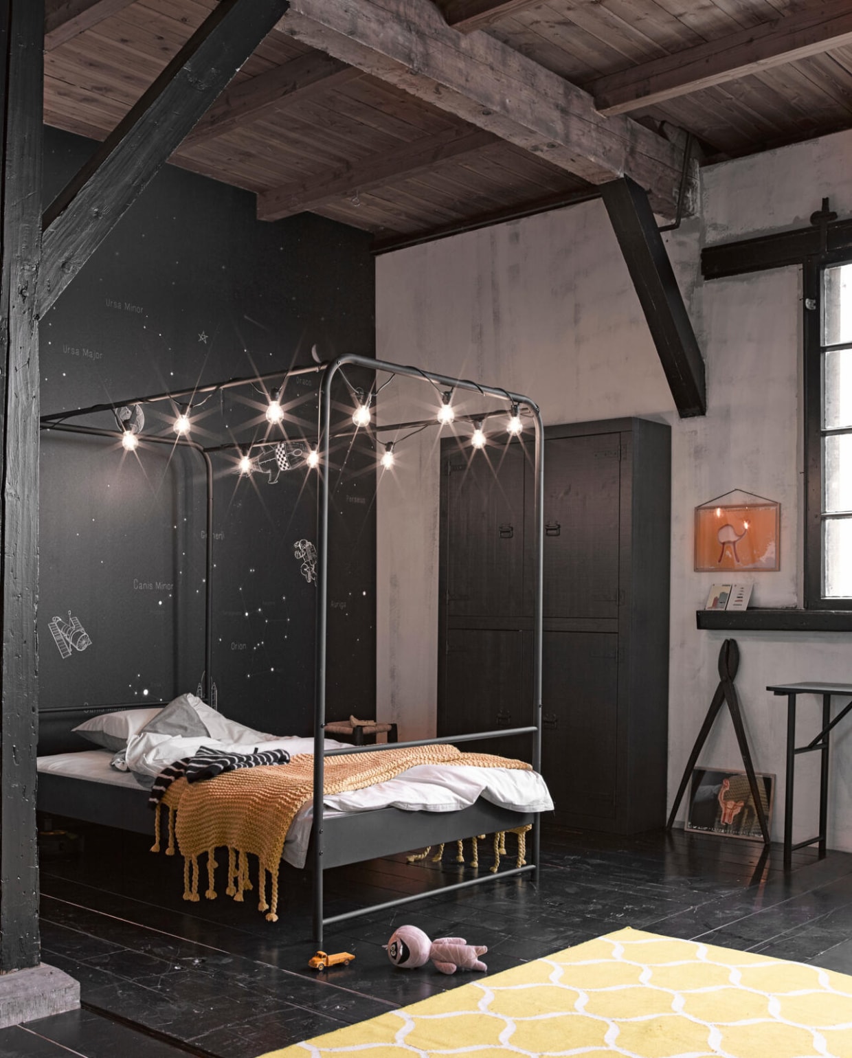 Zwartmetalen hemelbed Bunk, 120x200x206 cm (bxlxh) € 219,-, ook verkrijgbaar in formaat 90x200x206 (bxlxh) cm € 199,-. Behang Space, 300x300 cm € 149,-. M.m.v. Ikea (beddengoed, vloerkleed, knuffel), Loods 5 (gele plaid, houten schaar, geel etui op kruk), House Doctor (lichtsnoer), 10 days (kleding), moebe.dk (lijsten), lijst met beesten van elastiek (instagram.com/hvanonna). vtwonen 03-2018 | productie Inge Steketee | styling Fietje Bruijn | fotografie Alexander van Berge