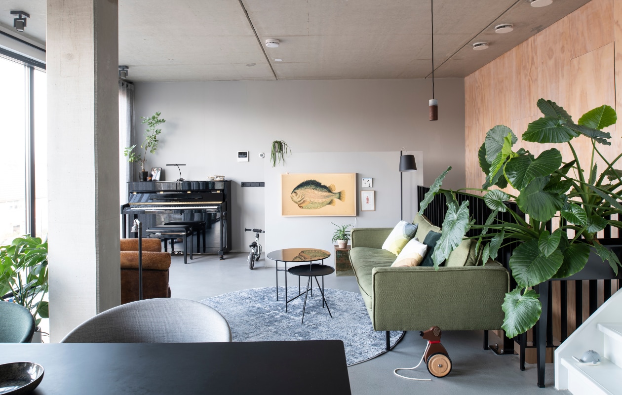 In de woonkamer op de tweede verdieping ligt Pandomo K3 stuc als variant op een gietvloer. Bank Loods 5 Design. Herringbone kussens van Vitra via Groen + Akker. Groen kussen en plantenstandaard Intratuin. Vloerkleed Gusta. Hoge bijzettafel Loods 5. Lage bijzettafel Woood. Vloerlamp Zuiver. Hanglamp Roest van Van Joost voor Graypants. TV Samsung Frame met camouflagebeeld vis. Tegel StoryTiles. Schilderij gekocht in een Parijse galerie. vtwonen 11-2021 | productie Insidehomepage | styling Inge van Lieshout | fotografie Louis Lemaire