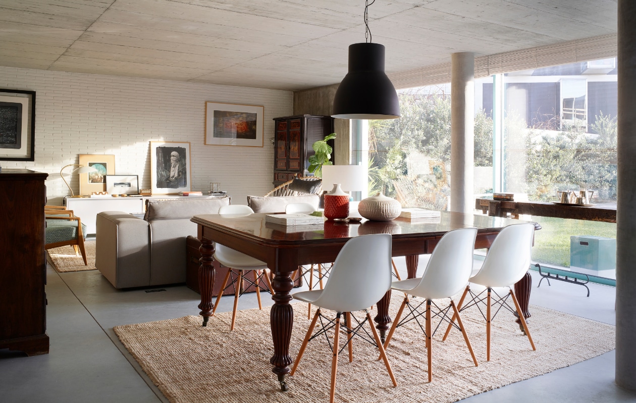 Antieke eettafel. Stoelen Eames DSW. Potjes op tafel Zara Home. Hanglamp en kleed Ikea. Bank en lage kast tegen de muur, beide ontworpen door Marta. De kunstwerken aan de muur en links op lage kast zijn gemaakt door Marta’s oom Bartolomeu Cid dos Santos. Groot zwart-wit kunstwerk rechts op lage kast, Sainer. Blauwe fauteuils vintage. Hoge kast antiek. vtwonen 05-2020 | styling Alison Cavanagh | fotografie Rachael Smith