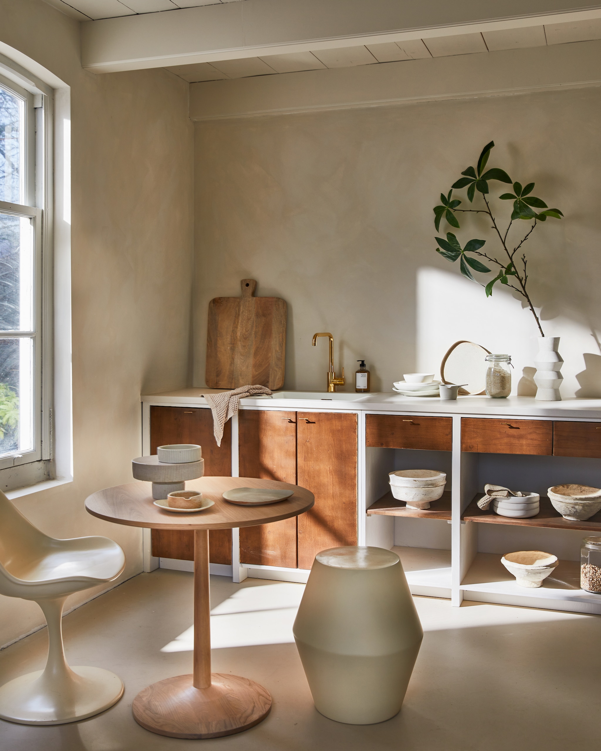 Keuken op maat, prijs op aanvraag (com-anders.nl). Eikenhouten tafel Turned, 75x70,5 cm (Øxh) vanaf € 608,- (bolia.com). Stoel € 539,-, kruk € 395,-, stapel servies links op aanrecht vanaf € 25,95  (householdhardware.nl). Snijplank € 104,95, papier-maché schalen € 45,- (nordal.eu). Minerale muurverf Fresco in Coffee Cream, per 2,5 liter € 129,94 (pure-original.com). Servies op tafel en rechts op aanrecht, prijs op aanvraag (marjokedeheer.com). Vaas € 44,95 (hkliving.nl). Overig privébezit. vtwonen 04-2023 | styling Cleo Scheulderman | fotografie Jeroen van der Spek