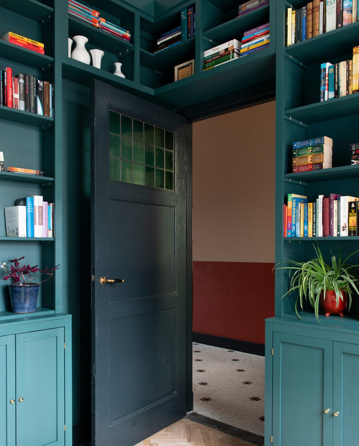 Visgraatvloer Loven Dageraad Vloeren. Boekenkast zelfgemaakt. Verf boekenkast Harley Green van Little Greene. Verf kozijnen en plinten Railings van Farrow &amp; Ball. Rode plantenpot gekregen. Muurverf hal: boven Setting Plaster van Farrow &amp; Ball, onder Terre D’Egypte van Farrow &amp; Ball. Tegelvloer Designtegels. vtwonen 03-2021 | fotografie Caroline Coehorst