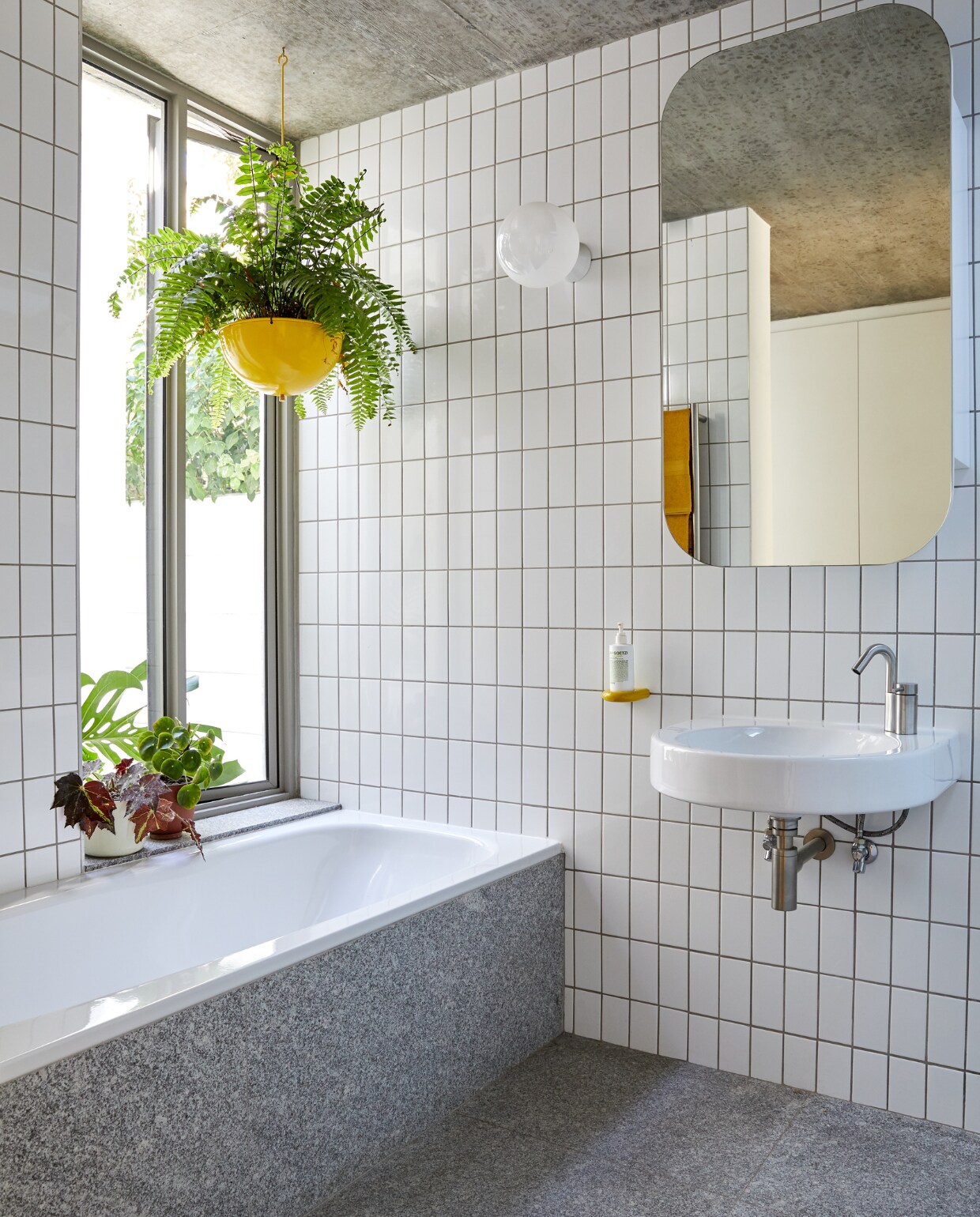 Tegels en spiegel bouwmarkt. Vloertegels Rustenberg. Wastafel Architec Duravit. Kraan Ottavo Quadro Design. Plantenpot Pedersen &amp; Lennard. Gele pomphouder System 111 Hewi. vtwonen special binnenkijken 12-2022 | productie Luanne Toms | fotografie Greg Cox/Frank Features