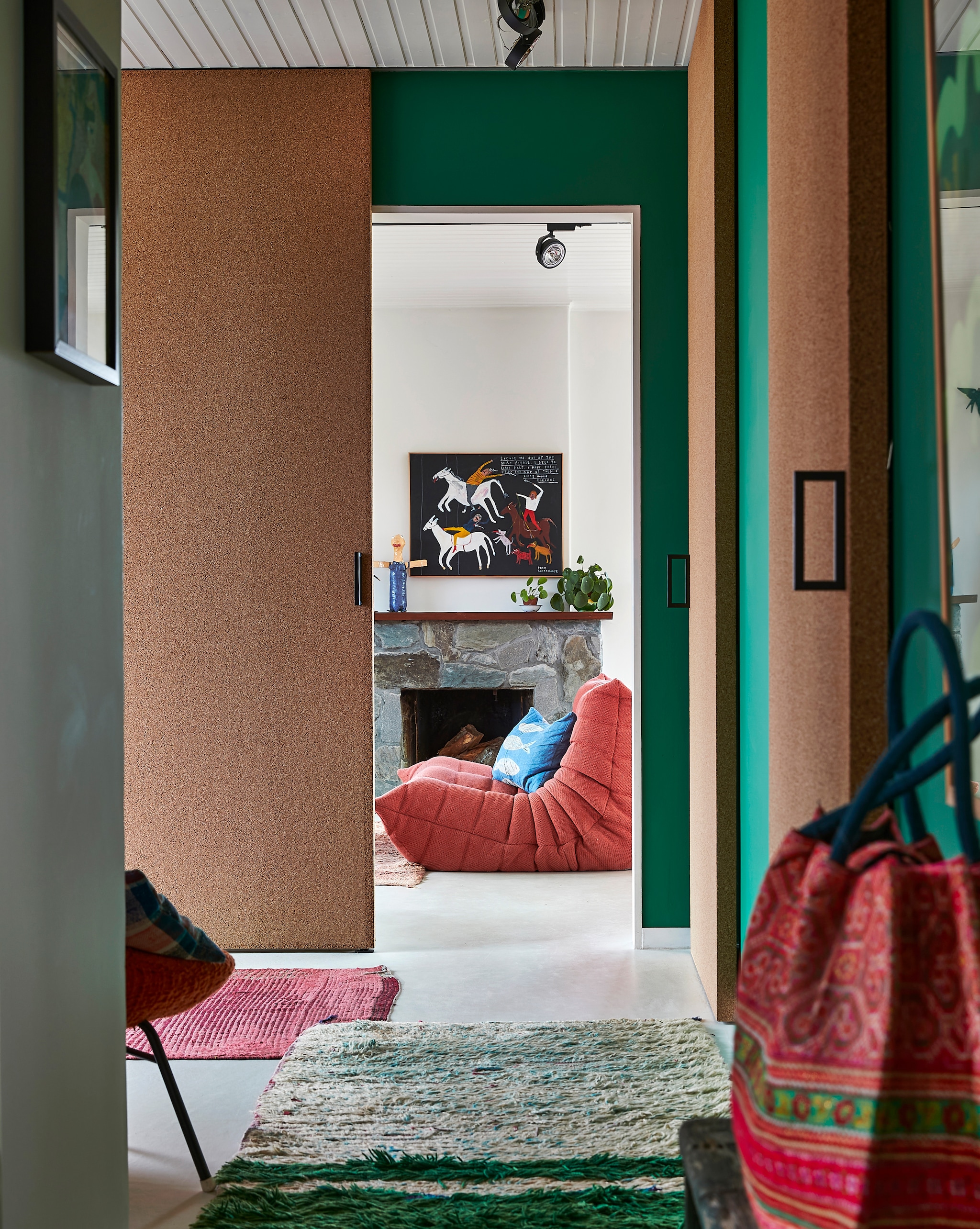 Muurverf Ressource. Kurkdeuren op maat gemaakt. Bank Togo Ligne Roset. Blauw kussen zelfgemaakt. Schilderij uit Engeland. Pop op de schouw bewaard knutselwerk van Ginger. Kleden uit Marokko. Rieten tas uit Thailand. vtwonen special binnenkijken 12-2022 | productie Living Inside | fotografie Jan Verlinde