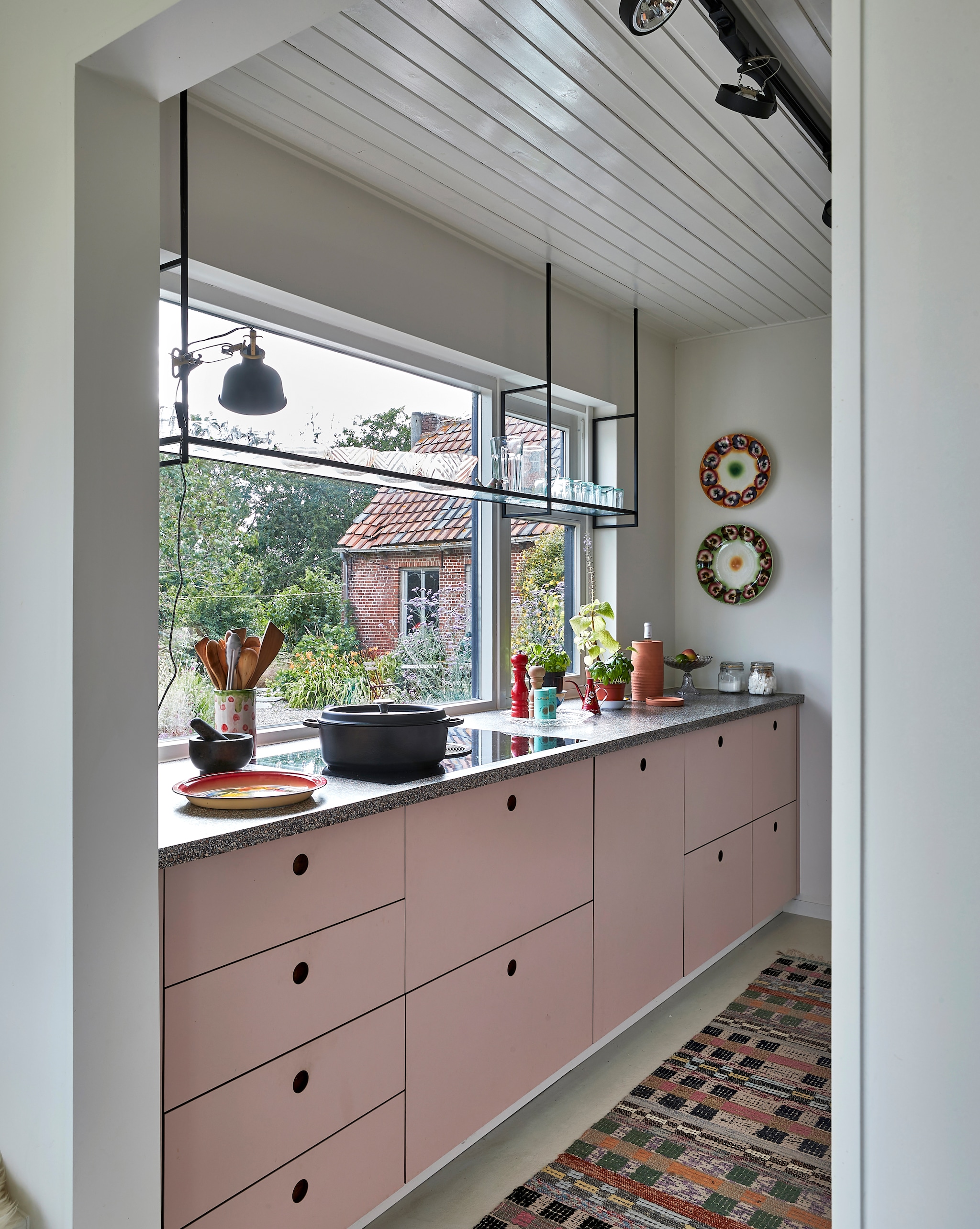 De zelfgemaakte keuken heeft een granitoblad op maat. Zweeds voddenkleed vintage. Wandborden uit Rusland. Overig onbekend. vtwonen special binnenkijken 12-2022 | productie Living Inside | fotografie Jan Verlinde