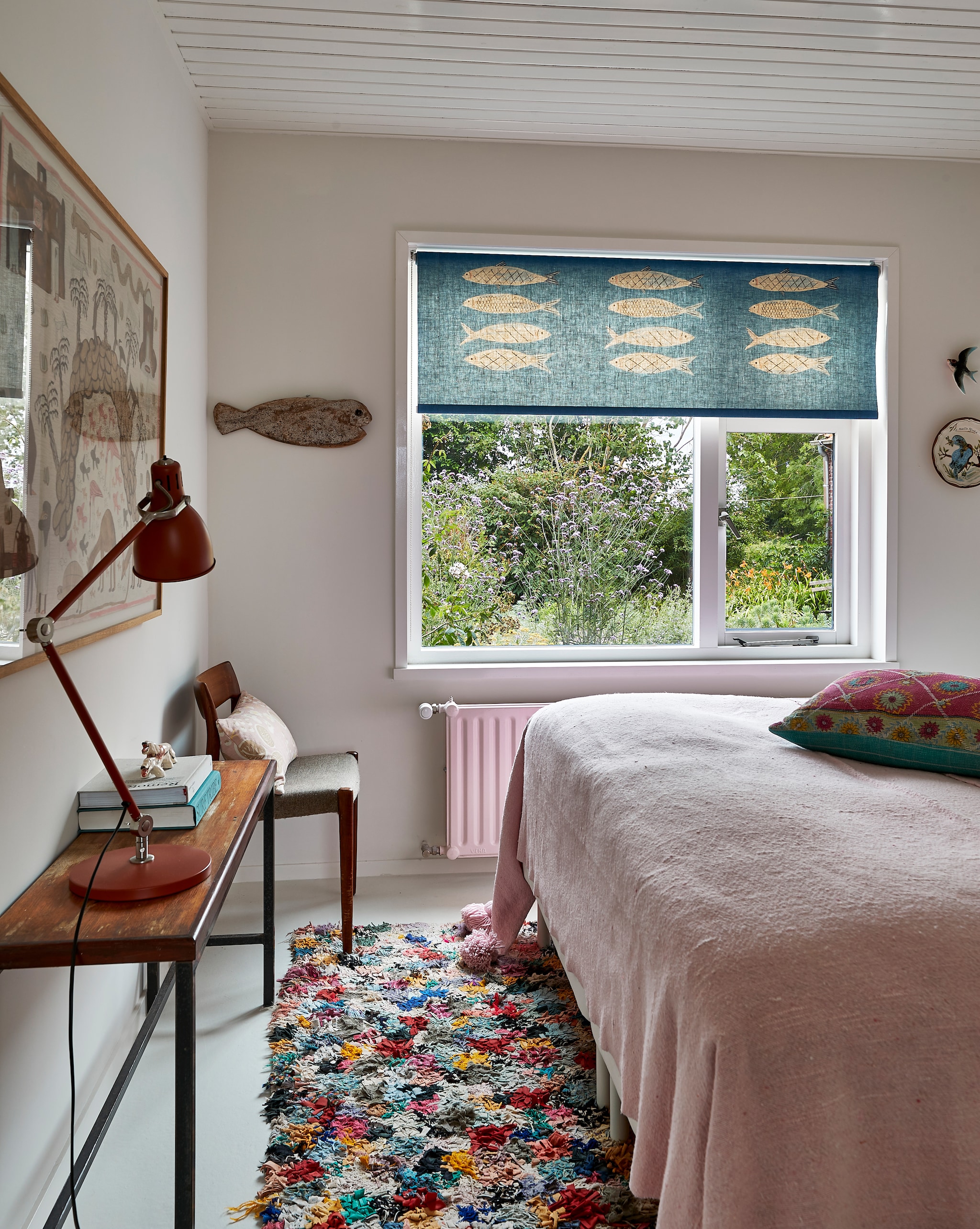 Rolgordijn en kussen op bed zelfgemaakt. Sprei, vloerkleed en ingelijst schilderij uit Marokko. Sidetable van de vorige bewoners. Lamp Ikea. Houten stoel familiestuk. Vis uit Zanzibar. vtwonen special binnenkijken 2022 | productie Living Inside | fotografie Jan Verlinde