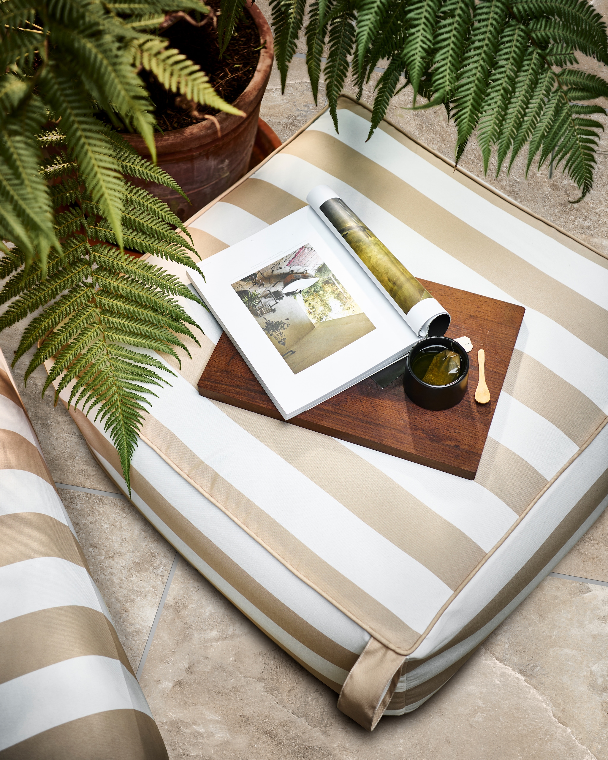 Opblaasbare poef Sit on Air in zand/wit, 72x72x35 cm (lxbxh) € 69,95. Ook verkrijgbaar in zwart/wit. Tuintegel Solostone Clouds, 70x70 cm per m² € 79,-. M.m.v. householdhardware.nl (zwarte mok). Overig privébezit.