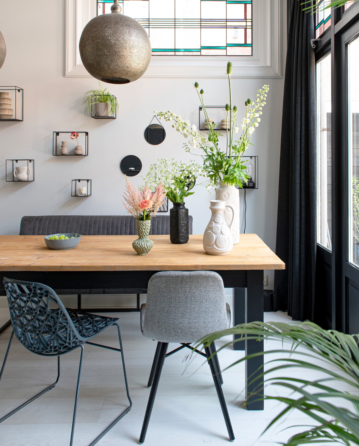 Eettafel uit Frankrijk, eetkamerstoelen en eetkamerbank Loods 5, bloemen Wim van Assem Bloembinderij, hanglampen Zenza Home, wandrekken vtwonen, fruitschaal Xenos, vazen vintage, houtverf kozijnen Ral 9005, muurverf Ral 9003. Overig onbekend. vtwonen 04-2023 | productie De Binnenkijkers | styling Jeske Weel | fotografie Caroline Coehorst