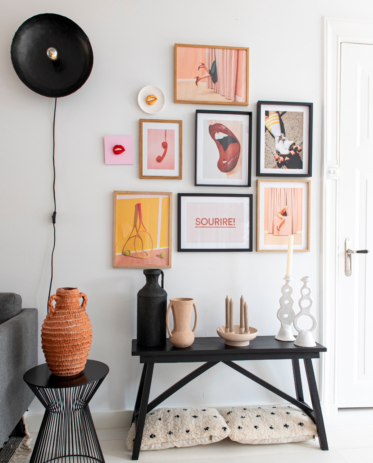 Posters Postery, bijzettafel Woood, houten bank Van Dijk &amp; Ko, kussens Benio, wandlamp Casa Gitane, kandelaar met vier kaarsen H&amp;M Home, witte kandelaars Household Hardware. Vazen v.l.n.r.: Household Hardware, Casa Gitane, Nordal. De kunstwerken met de lippen zijn gemaakt door Nathalie. vtwonen 04-2023 | productie De Binnenkijkers | styling Jeske Weel | fotografie Caroline Coehorst