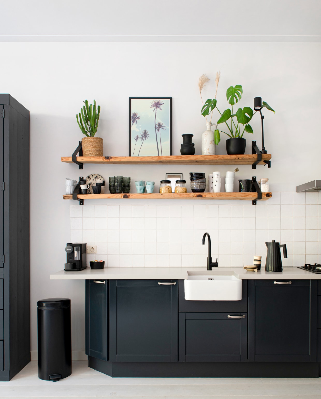 Keuken Tulp Keukens, pedaalemmer Brabantia, print palmen Juniqe, mokken op aanrecht HKliving, waterkoker Plissé van Alessi. Overig onbekend. vtwonen 04-2023 | productie De Binnenkijkers | styling Jeske Weel | fotografie Caroline Coehorst