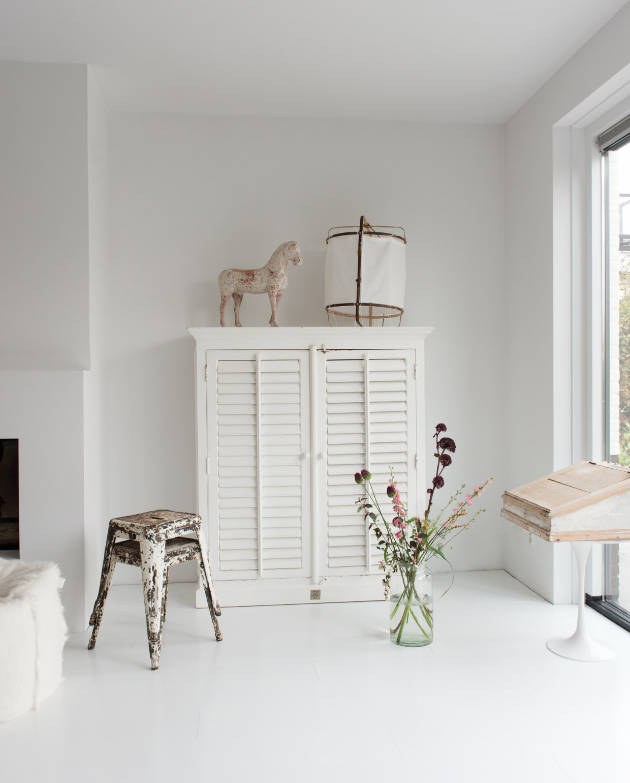 De tv-kast Riviera Maison. Originele krukjes Tolix uit 1934 gekocht bij een antiquair in Engeland. Op de kast: antiek paardje uit Zweden. Lamp Ay Illuminate. Wit vintage tafeltje marktplaats.nl. vtwonen 12 binnenkijken special 2019 | styling Wilma Custers (Features &amp; More), Rozmeen Koornneef | fotografie Trui Heinhuis