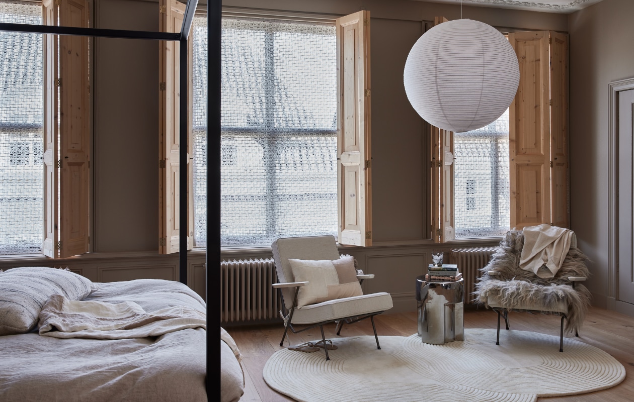 Hergebruikte houten luiken, prijs op aanvraag (). Opengewerkte polyester stof van Chivasso, hier toegepast als banier, kamerhoog 300 cm, per meter € 147,50 (jab.de). Stalen bedframe De Loft, 200x180x200 (lxbxh) € 1095,- (mattsleeps.com). Houtverf Sahara Dust, per liter € 55,75 (pure-original.com). Linnen dekbedovertrekset Amanda, 240x220 cm € 129,- (jotex.nl). Sprei Part van Ferm Living, katoen en linnen € 299,-, kussen Part van Ferm Living, katoen en linnen € 75,-, lampenkap Rice Paper Shade van Hay, 80 cm (Ø) € 78,99, vloerkleed Zen van Bolia, wol en katoen, 240x180 cm € 1294,- (vtwonen.nl/shop). Stenen bijzettafel, 35x45 cm (Øxh) € 195,- (hkliving.nl). Schapenvacht, wol en vilt € 95,- (natuurlijkvanmij.nl). Gekleurd drinkglas, set van 6 € 119,- (polspotten.nl). Witte blouse, prijs op aanvraag (madsnorgaard.com). Boeken, slippers en vintage fauteuils van Koene Oberman voor Gelderland privébezit. vtwonen 05-2023 | styling Marianne Luning | fotografie Alexander van Berge