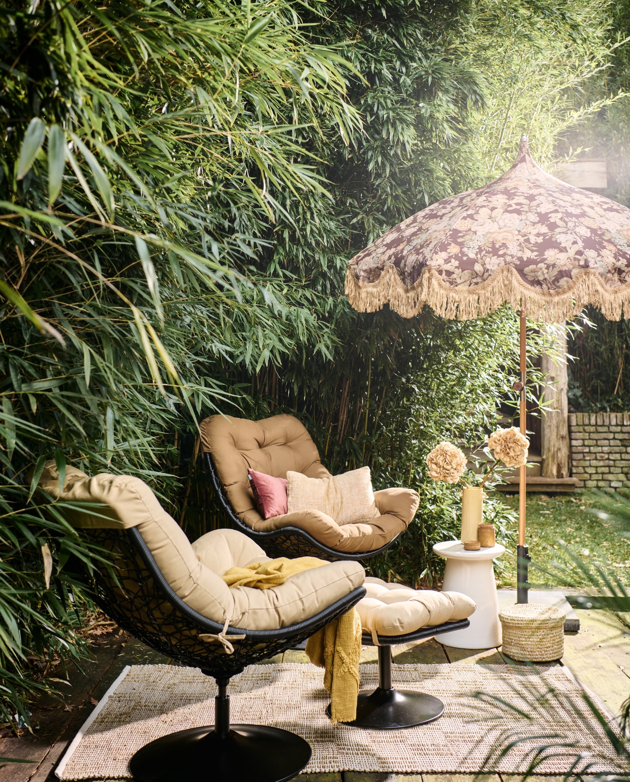 Rotan draaifauteuil Vive van Woood, met zitkussen, 82x105x100 cm (bxdxh) € 299,-, witte keramieken bijzettafel Button van vtwonen, 35x45 cm (Øxh) € 129,- (vtwonen.nl/shop). Rotan hocker Vive van Woood € 149,- (basiclabel.nl). Stoffen parasol uit collectie van Marie Olsson Nylander € 395,- (hkliving.com). Rieten mand, prijs op aanvraag (com-anders.nl). Gele keramieken vaas € 54,95, geel geweven kussen, 30x50 cm € 59,95, gele geweven plaid € 59,95 (urbannatureculture.com). Roze fluwelen kussen, 30x50 cm € 39,95 (hetkabinet.nl). Houten pot met deksel € 12,50 (jolandelijk.nl). Geweven vloerkleed van Madam Stoltz, 120x180 cm € 58,24 (deens.nl). Overig privébezit. vtwonen 05-2023 | styling Marlies Does | fotografie Sjoerd Eickmans | assistentie Mandy Kimmijzer