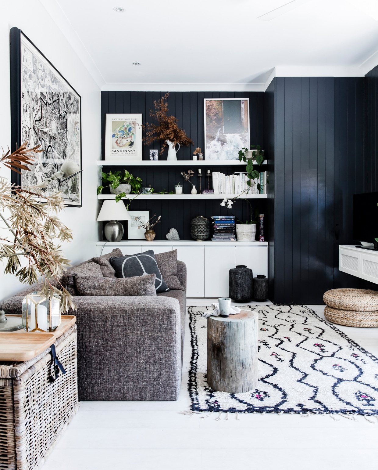 Muurkleur Domino Black van Dulux. Ets Grayson Perry. Bank Heals London. Vloerkleed Moroccan vintage. Mand, poefs, lamp en kan op plank Ikea. Bamboe dienbladen Freedom. Lantaarns en vazen op de vloer Papaya. Op de planken: print Kandinsky, potten Garden Life, kaars Maison Balzac, kandelaars David Mellor, hart Daylesford Organic. Overig onbekend. vtwonen special binnenkijken 2022 | productie Living Inside | fotografie Maree Homer