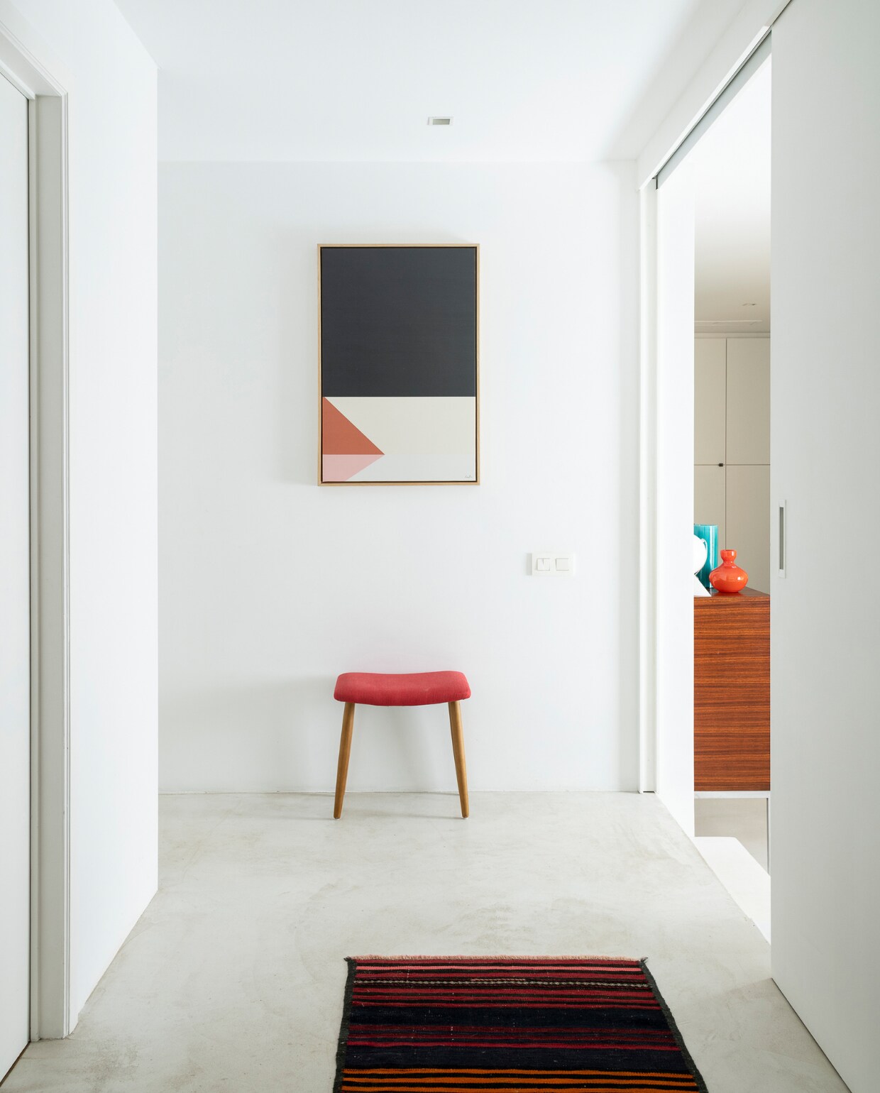 Kruk en kunstwerken Furnified, vloerkleed Christiaensen &amp; Christiaensen. Dressoir vintage, oranje vaas Dutz, overig onbekend. vtwonen 05-2023 | fotografie Jonah Samyn