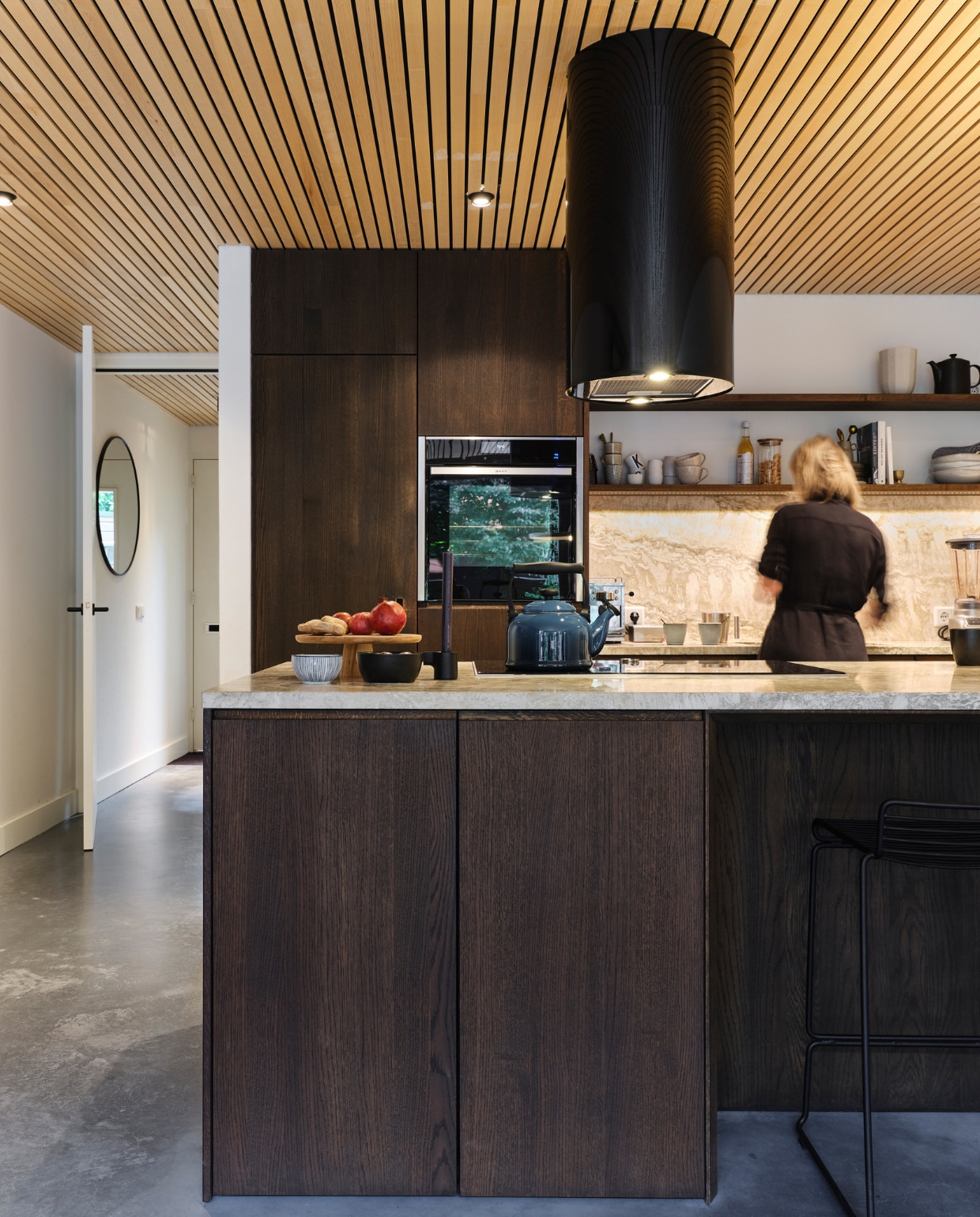 De keuken, met fronten van gebeitst eikenhout en een travertin blad en achterwand, ontwierpen Robbie en Dannieke zelf. Plateau Dille &amp; Kamille. Fluitketel Le Creuset. Barkruk en vaas Hay. Koffiemokken HKliving, H&amp;M Home en Piet Boon. Borden Sissy-Boy. Overig onbekend. vtwonen special binnenkijken 03-2023 | fotografie Rene van der Hulst