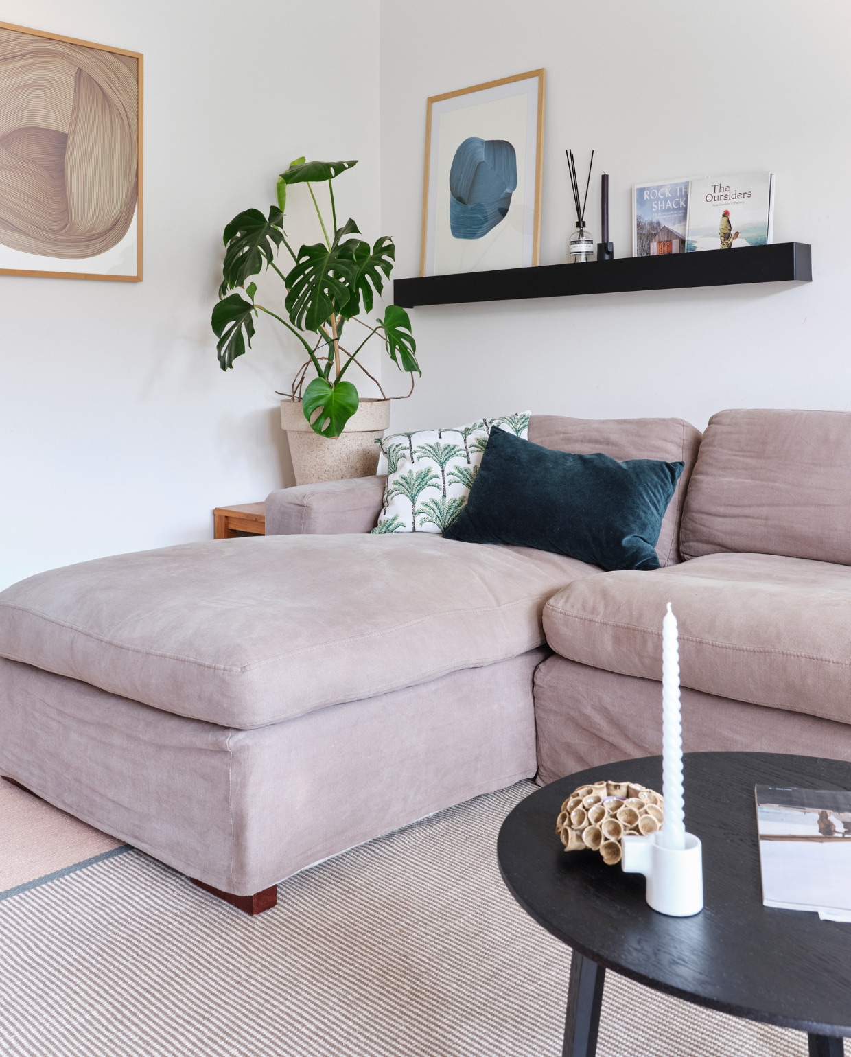 Bank en ornament op tafel kringloop. Kussen links H&M Home, rechts Ikea. Bloempot Sissy-Boy. Kunstprints Ronan Bouroullec in lijsten van Pienprent. Plank Wolfpak Studio. Salontafel en kandelaar Hay. Vloerkleed Perletta. vtwonen special binnenkijken 03-2023 | fotografie Rene van der Hulst