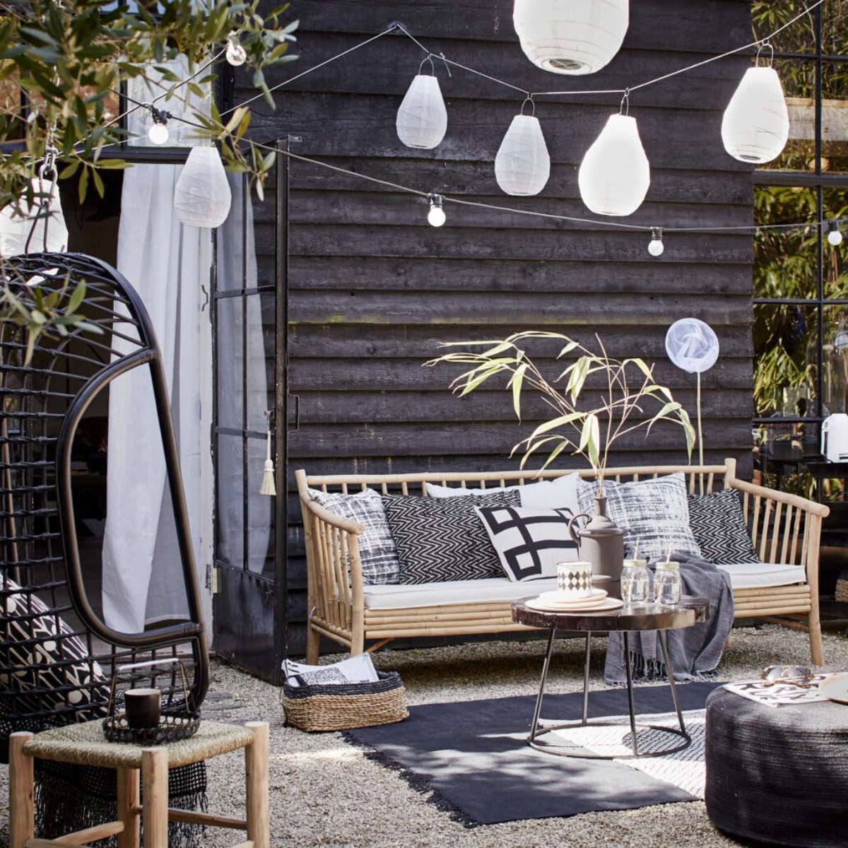 Bamboe bank van Tine K Home (l’Etoile Conceptstore). Kussens op de bank van linksaf: hoes met vervaagde ruit, Worn van House Doctor, 50x50 cm zigzagkussen Graphy van Casa Vivante 60x40 cm, wit kussen met zwart grafisch motief Lifestyle Manhattan 50x30 cm (www.vtwonen.nl). Plaid (Hammam 34). Rotan hangstoel van HK Living (www.vtwonen.nl). Erin kussen Feathers van Littlephant, 50x50 cm (Livv Lifestyle). Plaid (H&amp;M). Marokkaanse gevlochten kruk van HK Living, groot 37x37x42 cm, klein 31x31x25 cm, salontafel Kraton van Dutch Bone, Ø 60 cm, matzwarte vaas van Madam Stoltz, juten poef van HK Living, 30x70 cm (hxØ)(www.vtwonen.nl). Mason Jar drinkbekers set van 4 (vtwonen.nl). Houten bordjes van HK Living, emaillen zwart-wit potje set van 2 (www.vtwonen.nl). Rieten hoed (Sukha Amsterdam). Vloerkleed Stack van House Doctor; zwarte rotan stoel van House Doctor (www.vtwonen.nl). Zwart-wit vloerkleed (H&amp;M). Lampions Drop van House Doctor, lichtsnoer Bella Vista van Seletti, 10 lampen, 14,2 meter (www.vtwonen.nl). Visnet (Sissy-Boy Homeland). Gordijn set van 2 (Ikea). Rieten lage manden van Serax set van 3 (www.vtwonen.nl). vtwonen 2015-06 | fotografie Alexander van Berge | styling Cleo Scheulderman