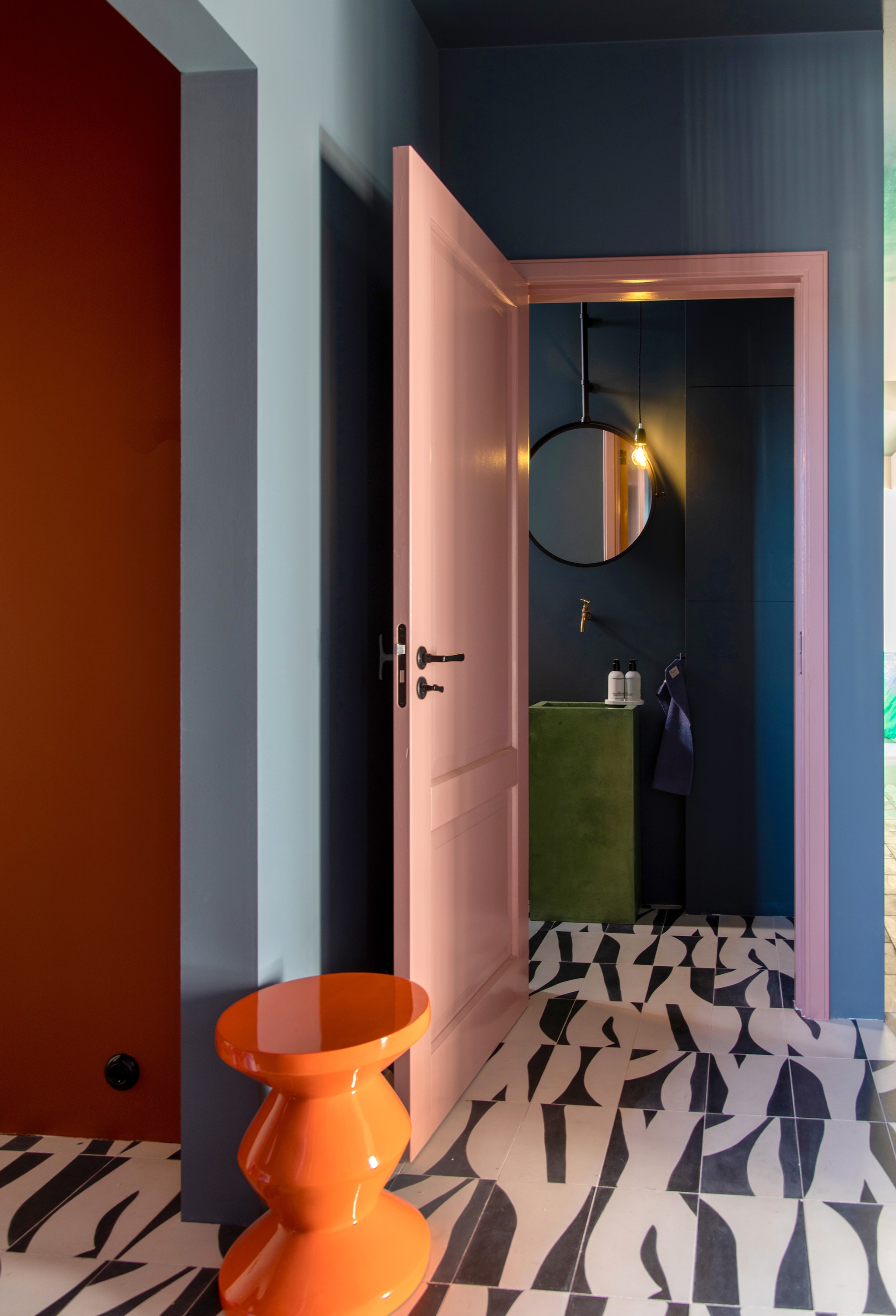 Bijzettafel Polspotten, vloertegels Popham Design via Rozetta, massief houten deur Karwei, gelakt in kleur B7.10.59, muurverf Puur Marmer van Flexa. Op maat gemaakte betonnen fontein Kok Beton, spiegel Dcw Editions. vtwonen 05-2023 | styling &amp; fotografie Theo-Bert Pot &amp; Jelle van de Schoor