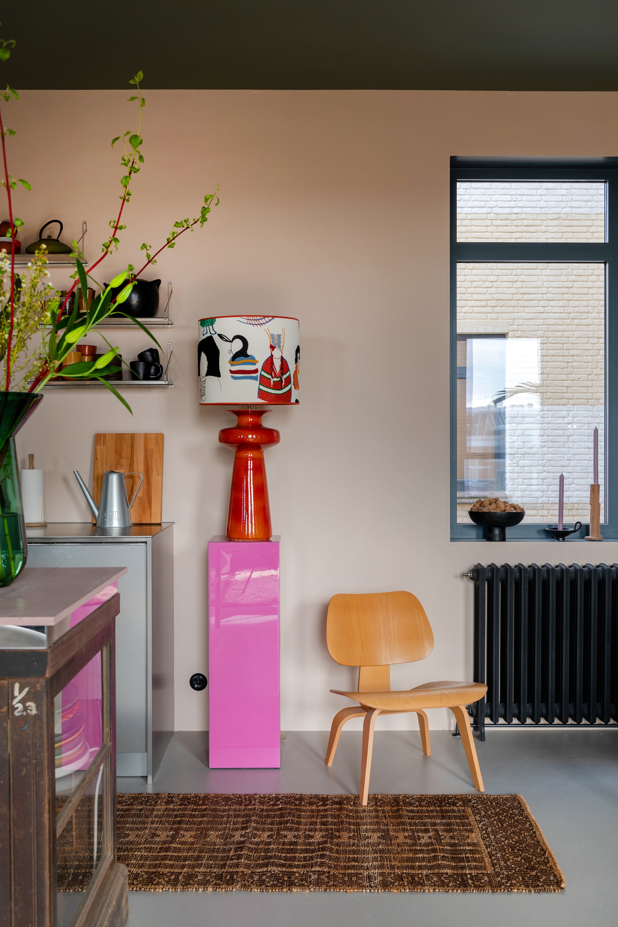 Verf aluminium kozijn Puur Marmer van Flexa, radiator The Classic House. Stoel Plywood van Vitra, kleed en roze pilaar HKliving, lampenvoet vintage, lampenkap Limonada. Keuken op maat Houtmerk, planken Frama via The Fine Store, mokken Edwin Pelser en Merci Paris, theepot Serax. Overig onbekend. vtwonen 05-2023 | styling &amp; fotografie Theo-Bert Pot &amp; Jelle van de Schoor