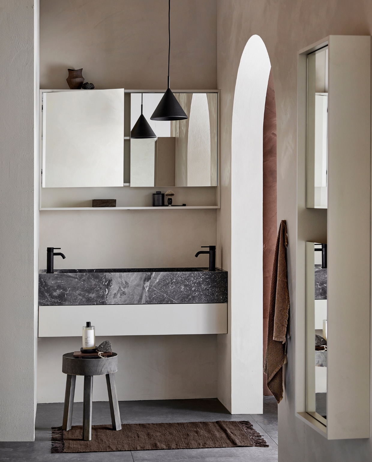 Marmeren wastafel Wide in Silver, 120x41x15 cm (bxdxh), ook in bruin, zwart en wit, met top solid mat gelakte onder-kast Tidy met push to open-lade in Zand, 120x40,5x20 cm (bxdxh), ook in wit, grijs en zwart, ( ). Kunststof spiegelkast Handy Beauty met dubbelzijdige spiegeldeuren in Mat Zand, incl. ledstrip met bewegingssensor, 120x16x80 cm (bxdxh) ( ), ook in zwart, wit en grijs. Kunststof kolomkast Handy Beauty Long met spiegeldeuren in matzand,  40x16x150 cm (bxdxh) ( ), ook in wit, grijs en zwart. Vloer- en wandtegel Raw Antracite Mat, 80x80 cm, ( ). M.m.v. plieger.nl (kranen Roma), vestingh.nl (muurverf Ibiza Rush en rechts Holy Monkey van Lab Paint), vtwonen.nl/shop (badmat van Ferm Living, lampen van HKliving), basiclabel.nl (kruk), zarahome.com (pot, schaaltje, dienblad, bodywash), hm.com (bakje, handdoek), bijenkorf.nl (scheerkwast). Overig privébezit. vtwonen 05-2023 | productie Tanja Saarberg | styling Sanne Ketelaar | fotografie Peggy Janssen