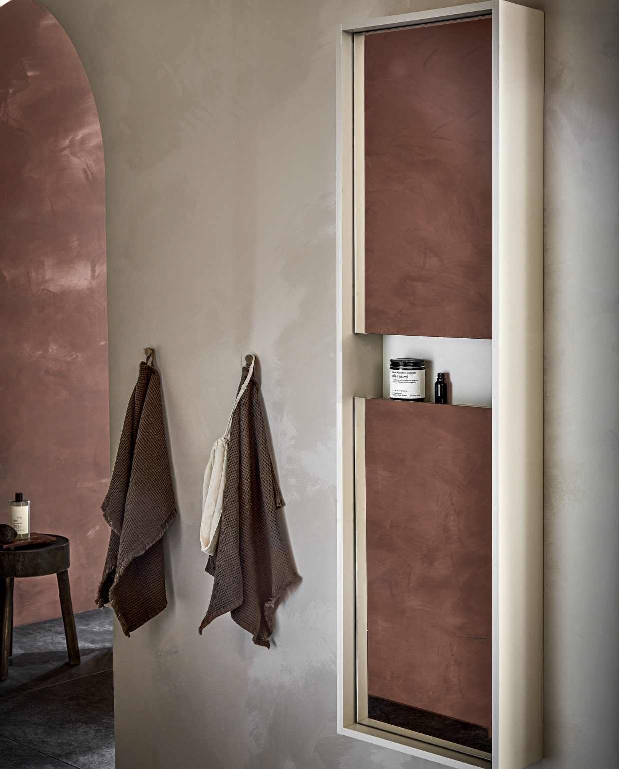 Kunststof Design kolomkast Handy Beauty Long met greeploze  spiegeldeuren in matzand, 40x16x150 cm (bxdxh), ook in wit, grijs en zwart. M.m.v basiclabel.nl (kruk), zarahome.com (dienblad, bodywash, geurkaars), hm.com (handdoeken). Overig privébezit. vtwonen 05-2023 | productie Tanja Saarberg | styling Sanne Ketelaar | fotografie Peggy Janssen
