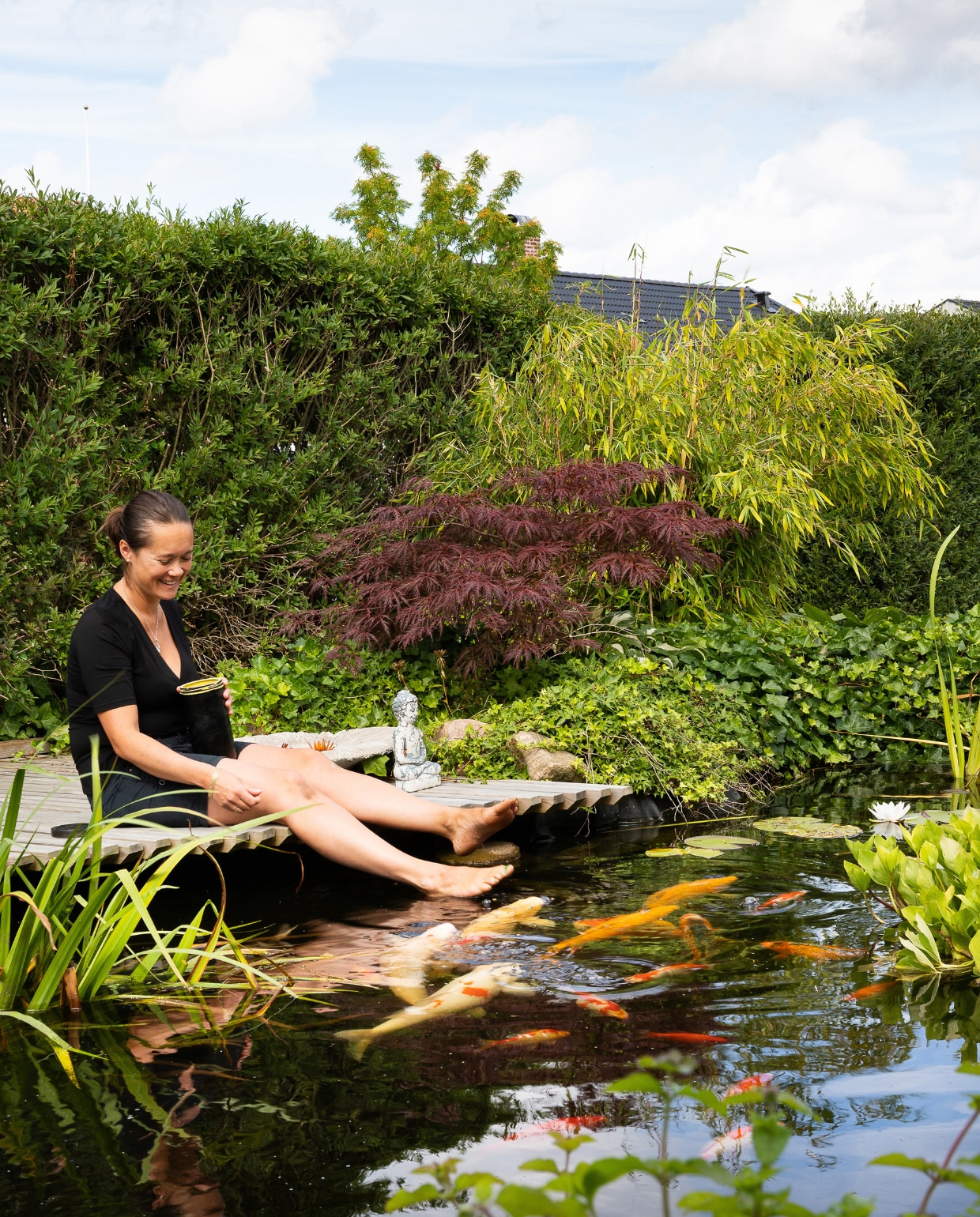 De vlonder is de perfecte plek om de bijna tamme kois te voeren. Op de achtergrond een Japanse esdoorn en parasolbamboe. vtwonen special tuin 08 | productie House of Pictures | fotografie Anna Örnberg