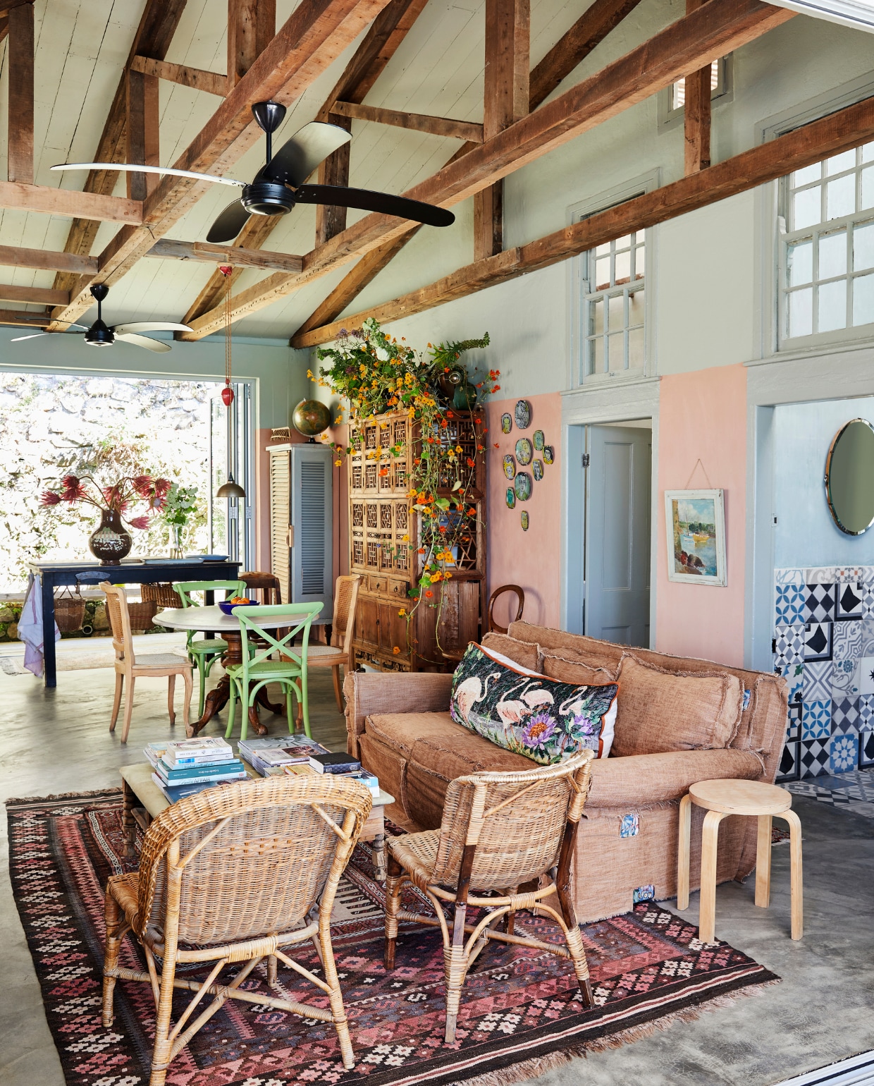 Bank, stoelen, tafels en vloerkleed tweedehands. Kruk Ikea. Kast Weylandts. Hanglamp Koöperasie Stories. Kussen zelfgemaakt. Keramieken wandborden Antoceramics. Wandtegels Moroccan Warehouse. In de vaas staan protea’s, een veelvoorkomende bloemensoort in Zuid-Afrika. vtwonen special binnenkijken 2022 | productie Bureaux | fotografie Warren Heath