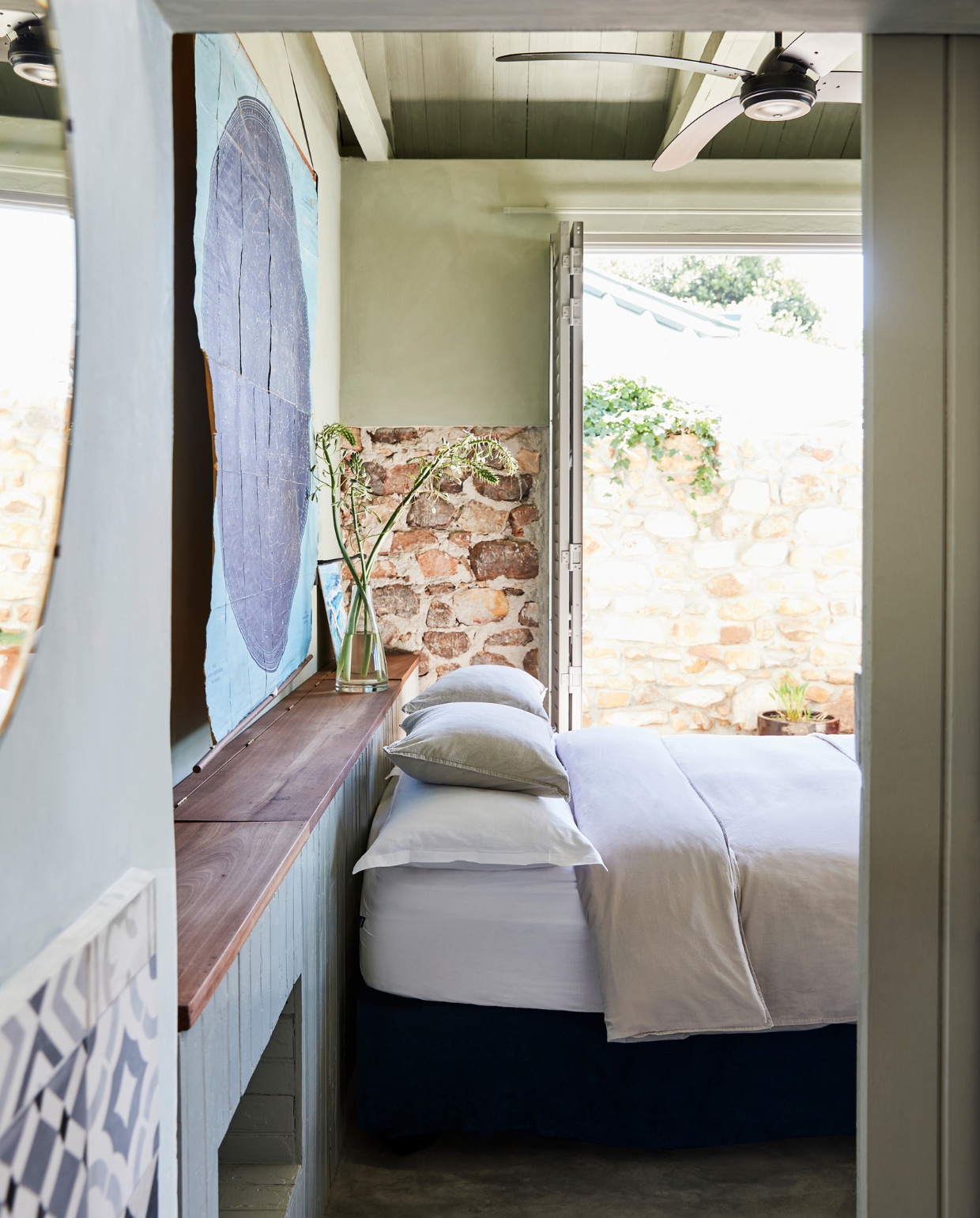Wandkast zelfgemaakt. Bed Tafelberg Furnishings. Print Koöperasie Stories. Spiegel gekocht op een markt. Tegels Moroccan Warehouse. Overig onbekend. vtwonen special binnenkijken 2022 | productie Bureaux | fotografie Warren Heath