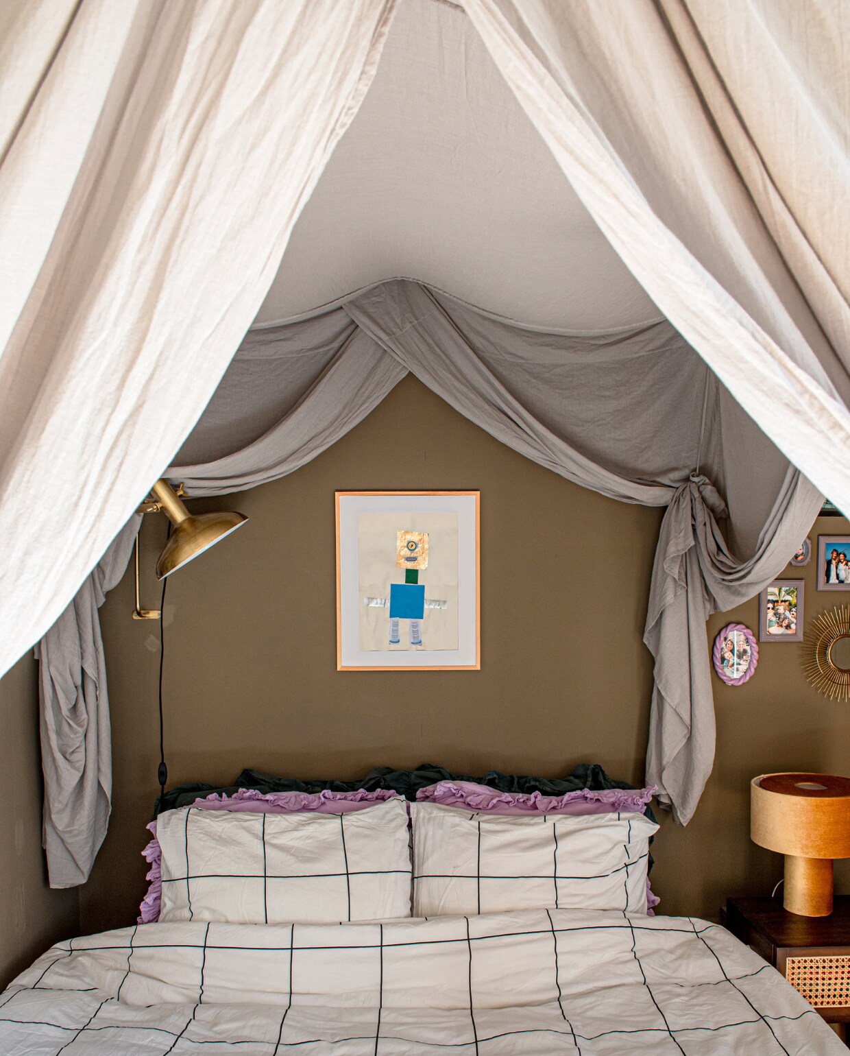 Verfkleur Broccoli Brown van Farrow &amp; Ball. Baldakijn Numero 74. Ingelijste tekening van Sef. Kleine lijsten &amp;Klevering en kringloop. Beddengoed en nachtkastje H&amp;M Home. Kussens Sissy-Boy. Tafellamp Westwing. Wandlamp Dutchbone. vtwonen binnenkijken special 131-2023 | fotografie Caroline Coehorst