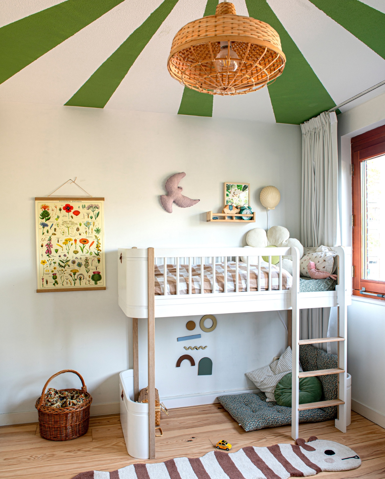 Groene verfkleur Yeabridge Green van Farrow &amp; Ball. Hanglamp en wandplank Ikea. Poster Fleur des Fleurs. Vogel KidsDepot. Nachtlamp HKliving. Hoogslaper Oliver Furniture. Beddengoed Zara Home. Bloemkussen Etsy. Grafische wandversiering MinMin Copenhagen. Kussens Zara Home en Studio Feder. Rupskleed Oyoy. Rieten mand tweedehands. vtwonen binnenkijken special 131-2023 | fotografie Caroline Coehorst