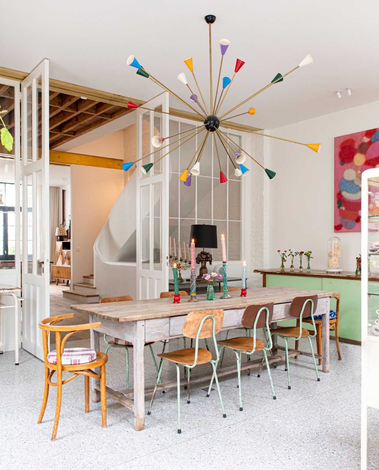 Sputniklamp  en stoelen tweedehands. Tafel en zwarte lamp cadeau gekregen. De groene kast was de toonbank van de lijstenmakerij. Overig onbekend. vtwonen special binnenkijken 131-2023 | fotografie Caroline Coehorst