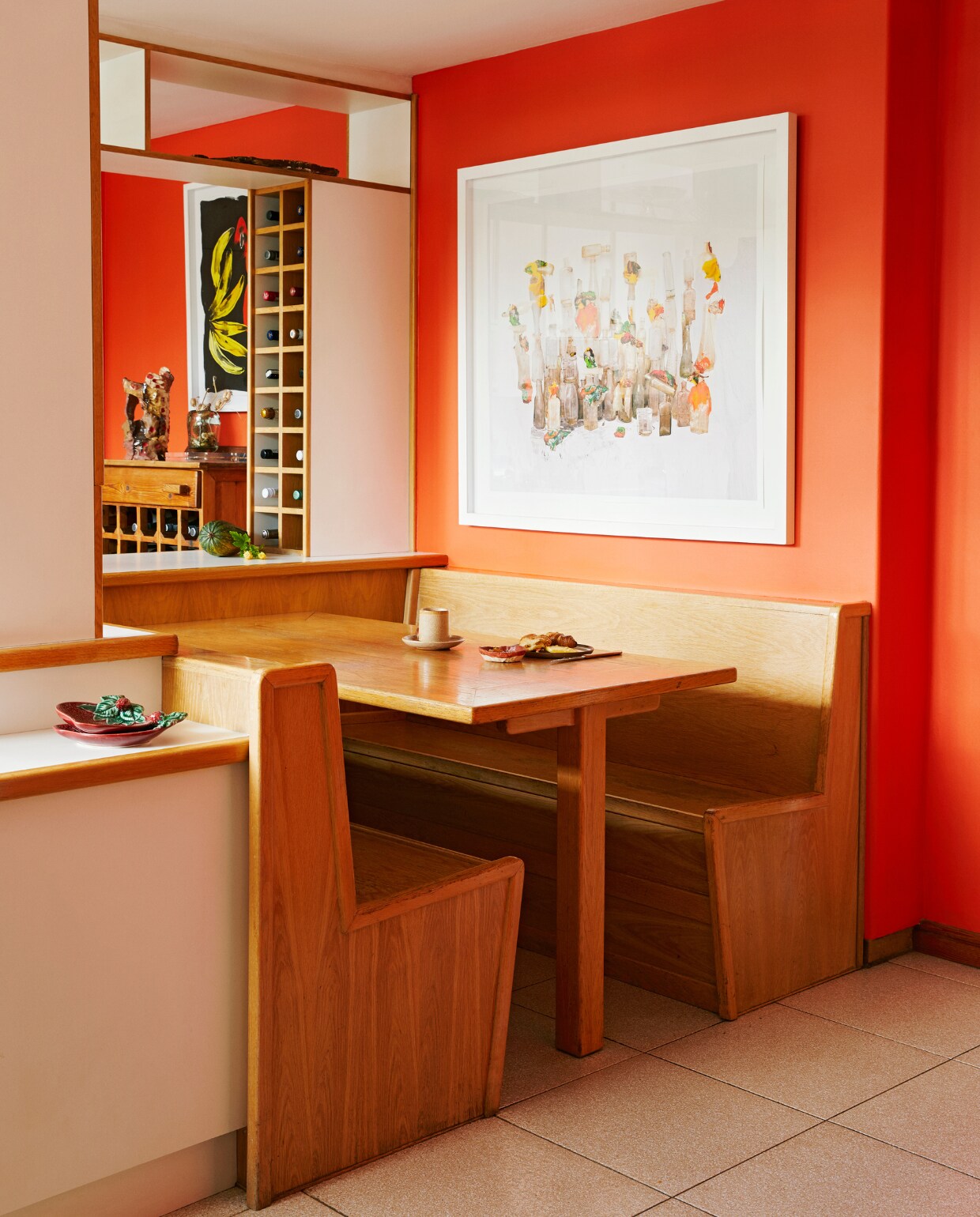 In de keuken zit een origineel, ingebouwd eethoekje. Vergelijkbare muurverf Puur Klaproos van Flexa. Kunstwerk Nico Krijno. vtwonen special binnenkijken 06-2022 | productie BUREAUX | styling Sven Alberding | fotografie Elsa Young