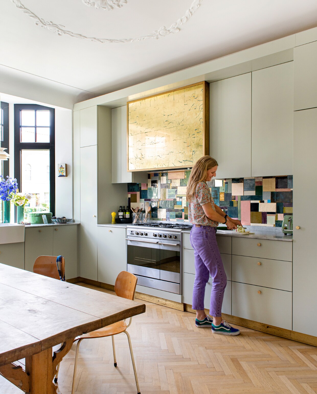 Keuken op maat gemaakt, fornuis Smeg. De spatwand is gemaakt i.s.m. keramist Cathy Deprez (@terretceterra), de afzuigkapombouw met decoratieschilder Céline Nassaux. Pepermolen Muuto. Tafel, stoelen, broodtrommel en vazen tweedehands. vtwonen special binnenkijken 131-2023 | fotografie Caroline Coehorst