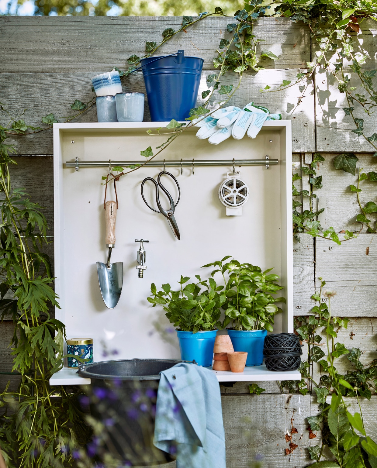 Blauwe emaillen emmer € 6,99, klos zwarte bindbuis € 5,49 (intratuin.nl). Blauwe mokken Tanzi, per stuk € 4,- (kwantum.nl). Verplantschop € 15,95 (dewiltfang.nl). Bloemenschaar € 9,95 (dille-kamille.nl). Theedoek € 2,- (hema.nl). Tuinhandschoenen € 6,95 (karwei.nl). Overig privébezit. vtwonen tuinspecial 8 | productie Corrien Flohil | styling Moniek Visser | uitvoering spel en buitenkraan Johan Snoodijk | fotografie Peggy Janssen