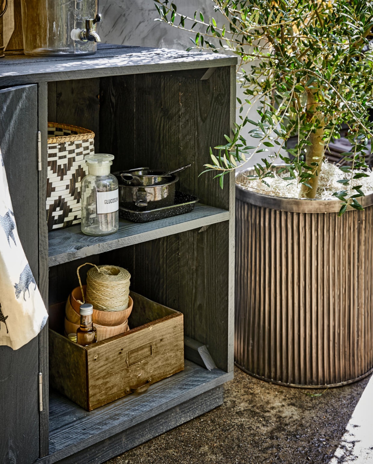 Geribbelde metalen plantenpot (De Weldaad). Kleine zwarte pannen, ecru borden (Madam Stoltz). Glazen limonadetap, zwart-witte manden (Nordal). Schort (H&amp;M Home). Laatje van hout (Burbri Antiek). Overig privébezit. vtwonen 07-2017 | styling Cleo Scheulderman | fotografie Jeroen van der Spek