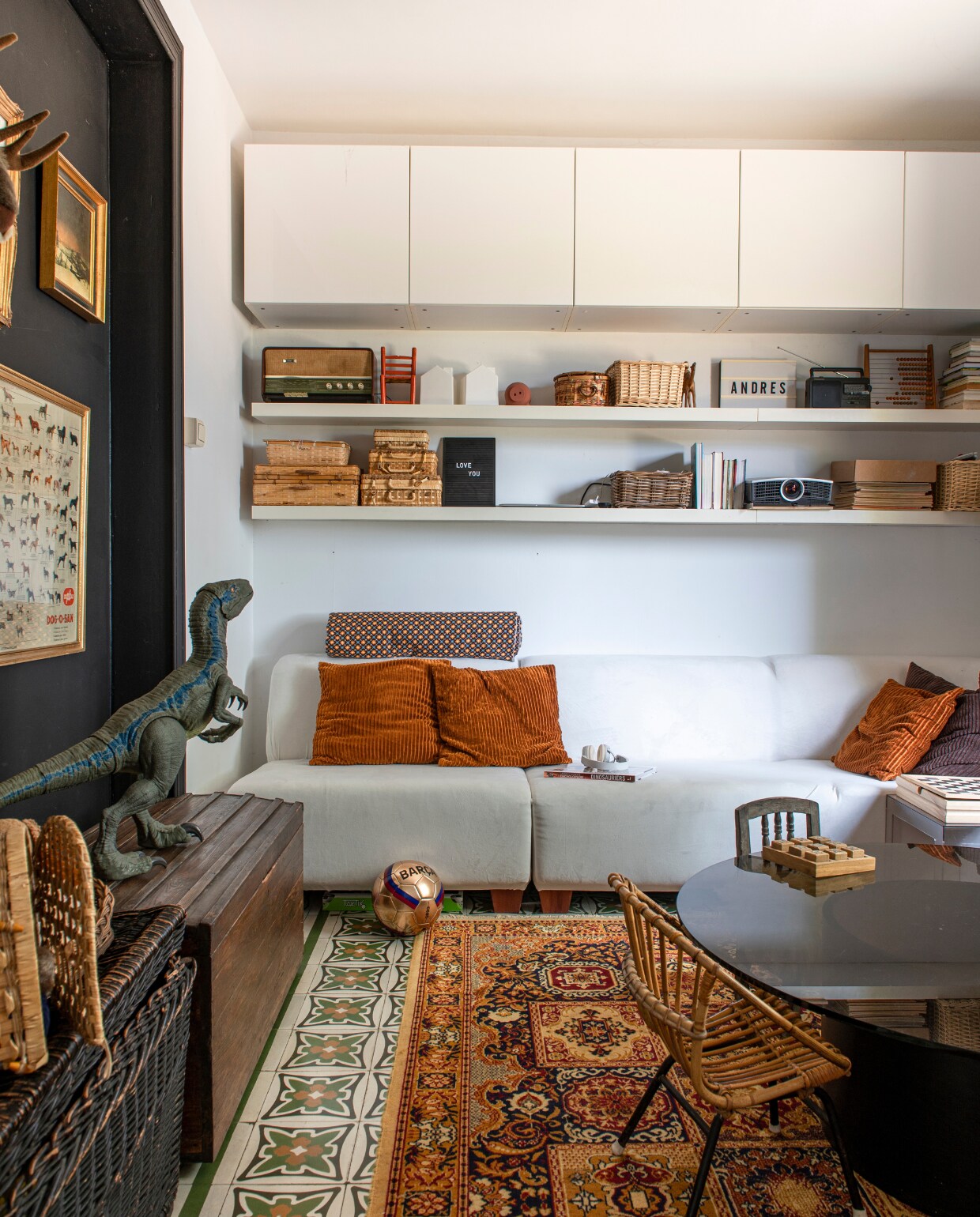 Wandkasten en -planken Ikea, zitmodules Maisons du Monde, fluwelen kussens Hema. Vintage rookglazen salontafel en dekenkist zijn erfstukken. Zwarte rieten speelgoedmand Sweet Living. Zwarte muur geschilderd in schoolbordverf. Overig kringloopwinkel vtwonen 06-2023 | productie De Binnenkijkers | styling Jeske Weel | fotografie Caroline Coehorst