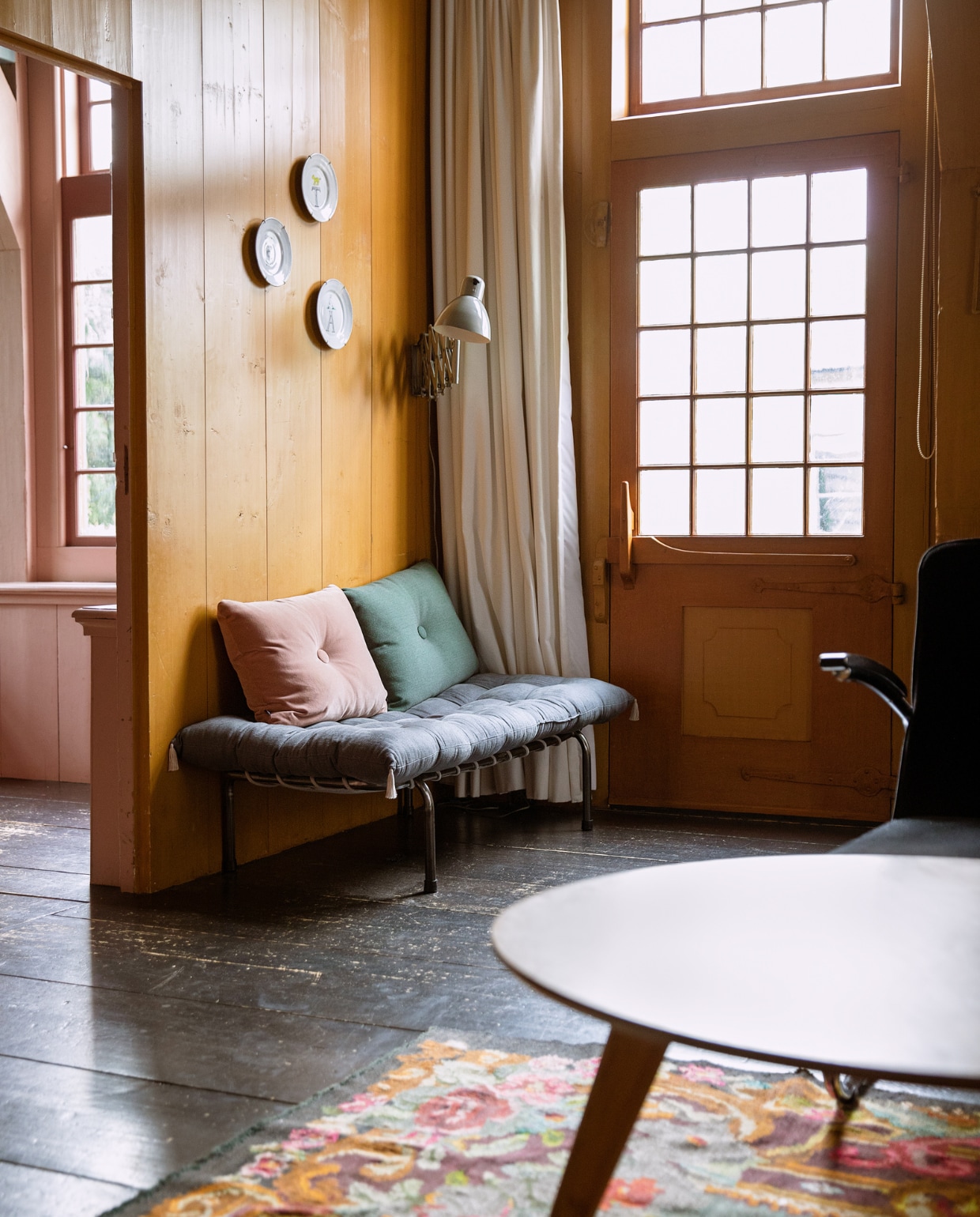 Borden aan muur Anouk Kramer, gordijnen Hema. Bank Numero 74, matraskussen Archive Store, kussens Hay. Stoel Gispen, salontafel Loods 5, Moldavisch vloerkleed Brechtje Olsthoorn Interiors.