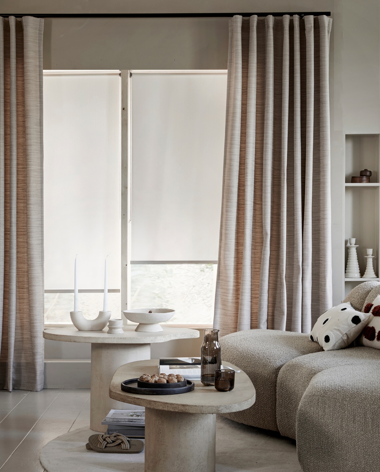 Lichtdoorlatend gordijn op maat met wave plooi in stof Sprinkle (1171), kleur Zand vanaf € 33,99 per strekkende meter. Lichtdoorlatend rolgordijn op maat wit visgraat (18012) vanaf € 128,19. M.m.v.: hkliving.nl (elementenbank Jax), vtwonen.nl/shop (kussen met stippen), bogard.eu (salontafel Palet, salontafel Steen). vtwonen 06-2023 | productie Tanja Saarberg | styling Marit Saladini Platjouw | fotografie Peggy Janssen