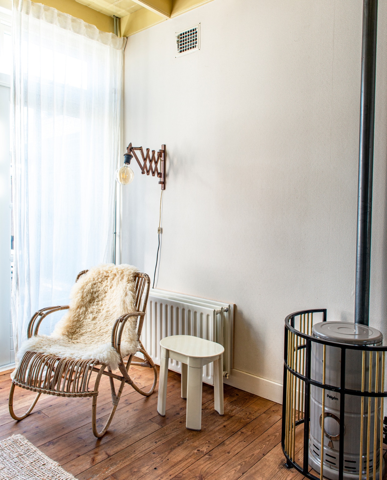 Linnen gordijnen Lejongap en schapenvacht Ikea. Rotanstoel van oma geweest. Wandlamp en kruk Olaf von Bohr kringloop. vtwonen special binnenkijken 03-2023 | productie De Binnenkijkers | styling Jeske Weel fotografie Caroline Coehorst