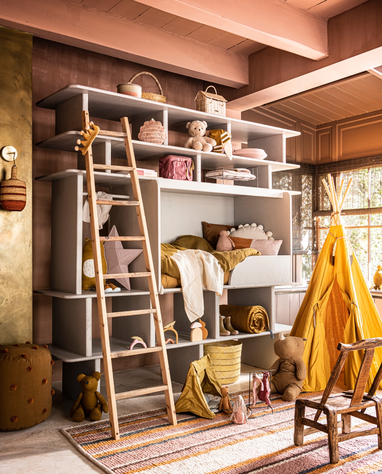 Verfkleur op wand Cypria van Carte Colori, 2,5 liter € 136,80, plafondlamp Maron, prijs op aanvraag, goudkleurige wand metallic stuc via Estudio, prijs op aanvraag, raambekleding Indivipro, prijs op aanvraag, bord Wonki Ware € 23,-, mok Wonki Ware € 19,- (brechtmurreatelier.nl). Handgemaakt hemelbed, prijs op aanvraag (com-anders.nl). Roze kussen met bruine streep € 125,-, roze kussen links daarboven € 163,- geel en roze linnen kussens, onderdeel van dekbed, per stuk € 39,-, geel en roze linnen dekbedovertrekken, per stuk € 325,-, langwerpig lichtgeel kussen € 215,-, dienblad, onderdeel van bijzettafel € 275,-, pet € 59,-, vaas € 1260,-, mand waar cactus in zit, onderdeel van salontafel € 275,-, kralenketting € 119,-, plaid met gele streep € 115,-, vloerkleed, 150×78 cm € 245,-, poef, 80×60 cm € 495,-, kussen met streepmotief achteraan € 249,- (couleurlocale.eu). Bruine glazen vaas Balloon van Normann Copenhagen, 19×7 cm (hxØ) € 36,80, rood schaaltje Merci van Serax, 15 cm € 21,40, groen langwerpig gestreept kussen van HKliving € 32,95, linnen servet van HKliving, set van 2 € 15,45, geel/groen kussen € 34,95 (vtwonen.nl). Bloem in vaas en cactus, prijs op aanvraag (plantje.nl). Geel kussen met stiksels, 70×70 cm € 147,50, ochtendjas € 85,- (archive-store.nl). Hoed € 34,99 (koconceptstore.nl). Staande lamp € 119,- (sissy-boy.com). Houten kruk vanaf € 339,- (polspotten.nl). Hanglamp voor bed € 29,-, groene schaal € 16,- (householdhardware.nl). Sandalen € 59,99, set leren doosjes op tafeltje, vanaf € 29,99 (zarahome.com). Goudkleurig tafeltje € 169,-, onderste boek op stapel € 37,50 (maisonnl.com). Bovenste boek op stapel € 40,- (sukha.nl). Overige boeken privébezit. vtwonen 07-2021 | styling Liza Wassenaar | fotografie Sjoerd Eickmans