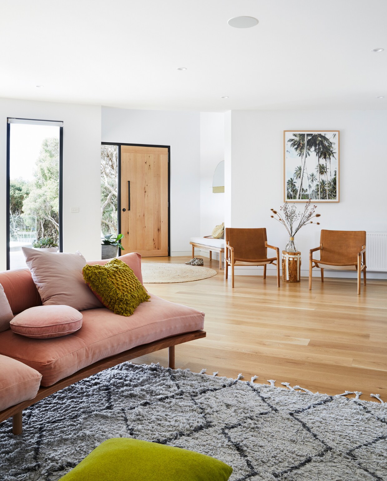 Bank Pop and Scott. Vloerkleed Early Settler. Leren stoelen Barnaby Lane. Palmenprint Coastal Living Sorrento. Overig onbekend. vtwonen special binnenkijken 07-2022 | productie Living Inside | styling Julia Green | fotografie Armelle Habib