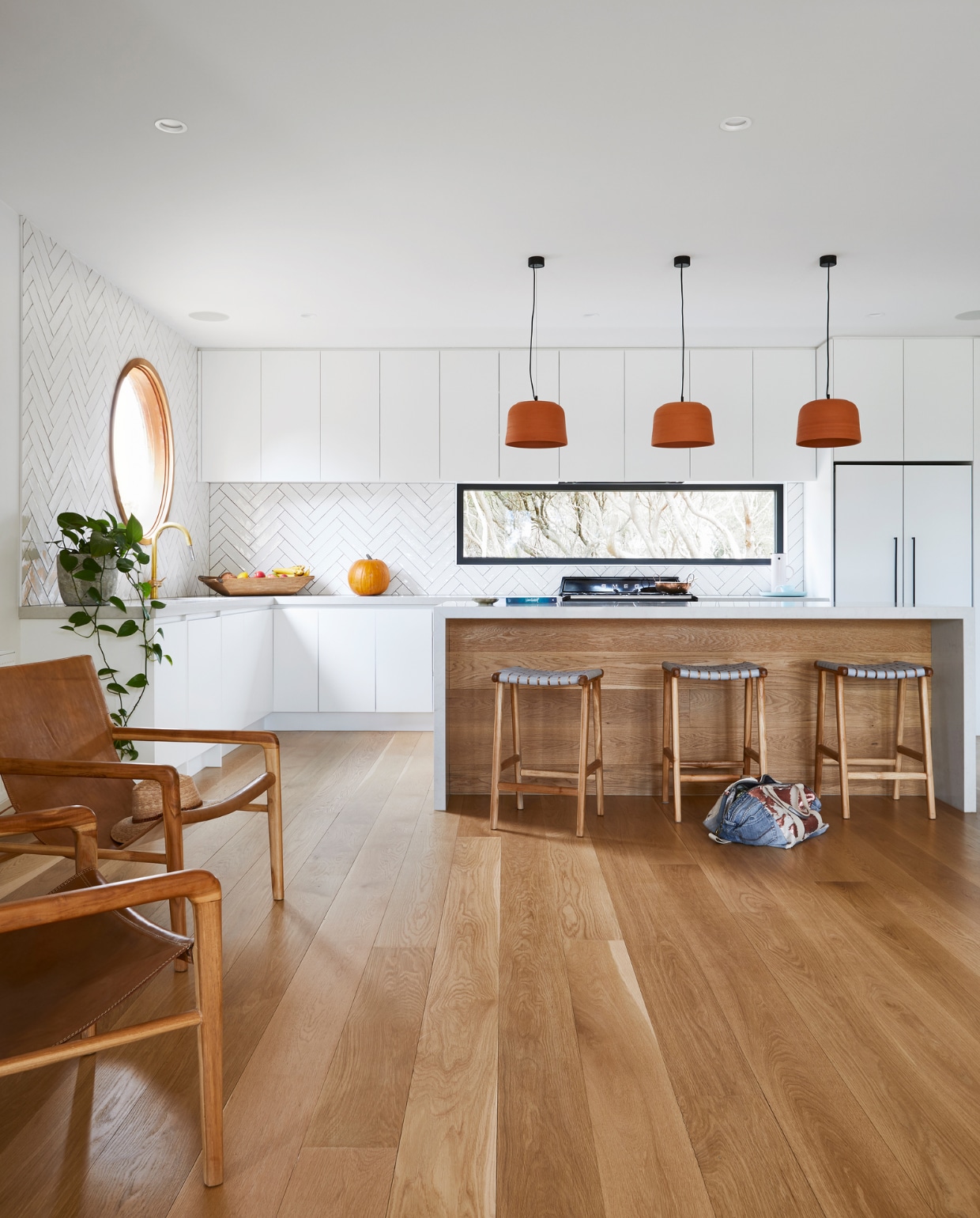 Leren stoelen Barnaby Lane. Keukenkasten geschilderd in White on White van Dulux. Kraan Reece. Handgemaakte wandtegels Masia Blanco van National Tiles. Barkrukken Fenton &amp; Fenton. Soortgelijke hanglampen via Atelier91. Overig onbekend. vtwonen special binnenkijken 07-2022 | productie Living Inside | styling Julia Green | fotografie Armelle Habib