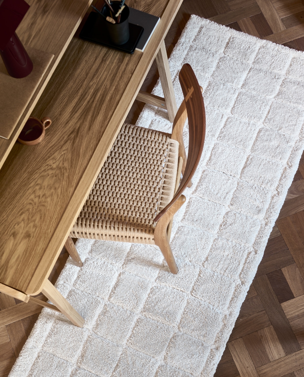 Vloerkleed Blocks in Warm white, polyester en jute (loperformaat), 80x240 cm. Ook verkrijgbaar in Warm brown. M.m.v. vtwonen.nl/shop (bureau van Kave Home), homestede.nl (tafellamp), zarahome.com (metalen pennenbak), lennebelle.com (keramieken kop). Overig privébezit. vtwonen 06-2023 | productie Tanja Saarberg | styling Sanne Ketelaar | fotografie Sjoerd Eickmans | assistentie Evans van der Sluis
