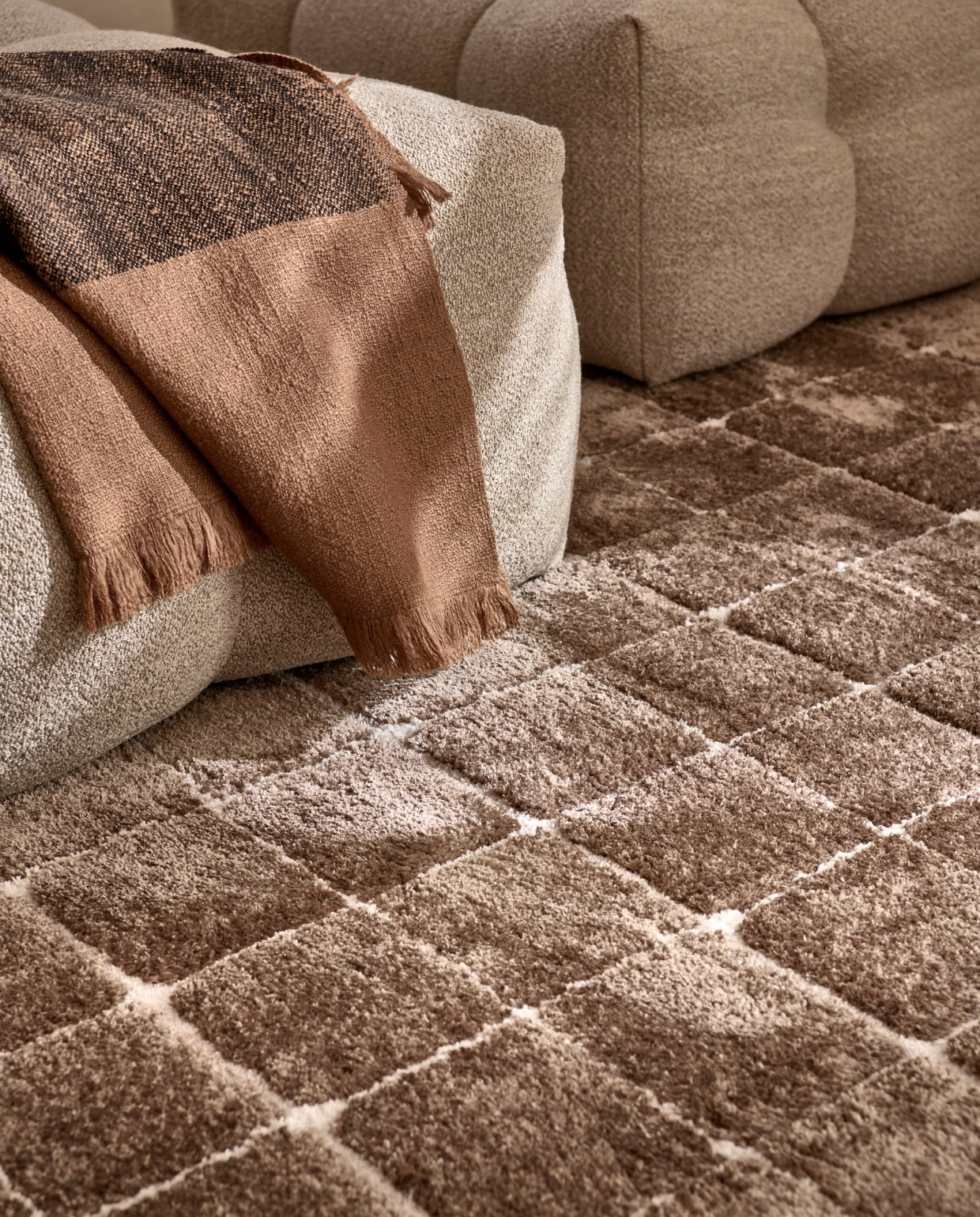 Vloerkleed Blocks in Warm Brown, polyester en jute, 240x330 cm. Ook verkrijgbaar in Warm white. M.m.v. studiohenk.nl (fauteuil), vtwonen.nl/shop (plaid van Ferm Living). vtwonen 06-2023 | productie Tanja Saarberg | styling Sanne Ketelaar | fotografie Sjoerd Eickmans | assistentie Evans van der Sluis