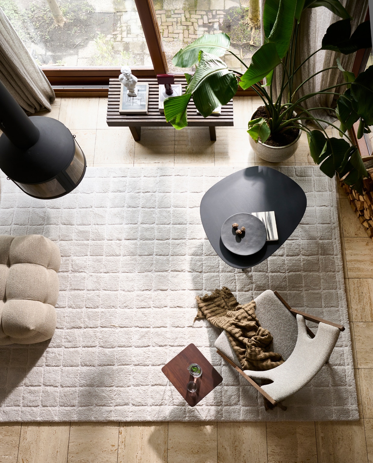 Vloerkleed Blocks in Warm white, polyester en jute, 240x330 cm. Ook verkrijgbaar in Warm brown. M.m.v. designtales.nl (fauteuil, zwarte salontafel), loods5.nl (houten salontafel Philipa, hocker Fat Joe), zarahome.com (waterglas, glazen karaf, plaid), homestede.nl (dienblad, tafellamp), vitra.com (notenhouten bijzettafel). Overig privébezit. vtwonen 06-2023 | productie Tanja Saarberg | styling Sanne Ketelaar | fotografie Sjoerd Eickmans | assistentie Evans van der Sluis