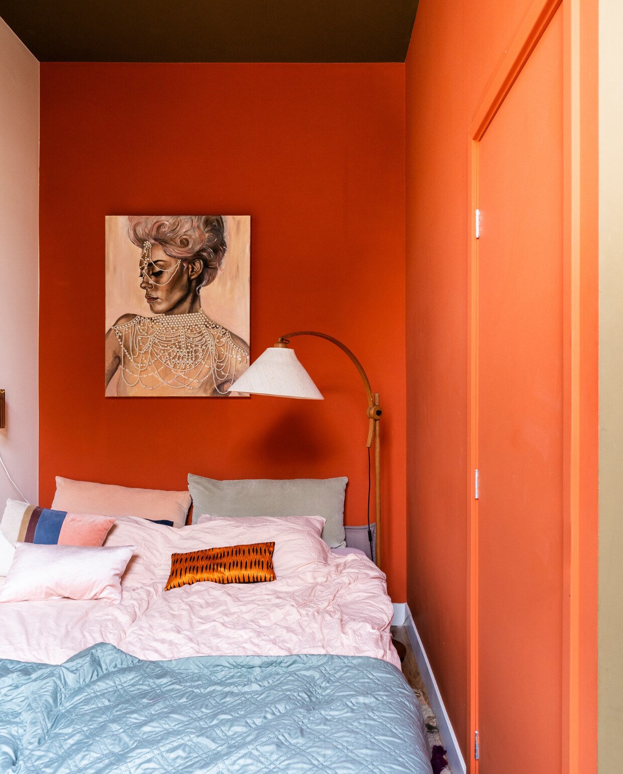 Muurverf links E04.07.82 van Flexa, rechts D3.55.38 en plafond F6.30.30 van Sikkens. Kunstwerk Let Them Eat Pearls van Tess Anders. Vloerlamp Domus Sprinkelhop.  Dekbedovertrek Crisp Sheets. Gestreept kussen HKliving. Oranje kussen Mariska Meijers. Overig onbekend. vtwonen special binnenkijken 03-2023 | productie CocoFeatures | fotografie Muk van Lil