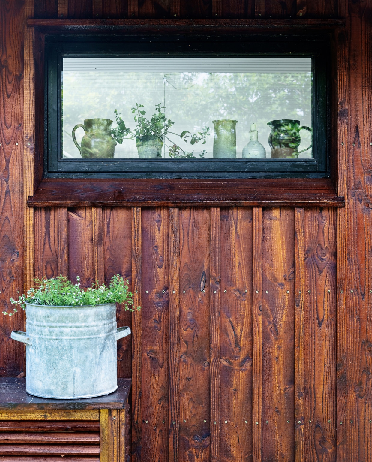 Het huis is rondom bekleed met verticale douglasplanken, afgewerkt met Fins teer. vtwonen special binnenkijken 06-2022 | productie Living Inside | styling Rikke Graff Juel | fotografie Christina Kayser O.